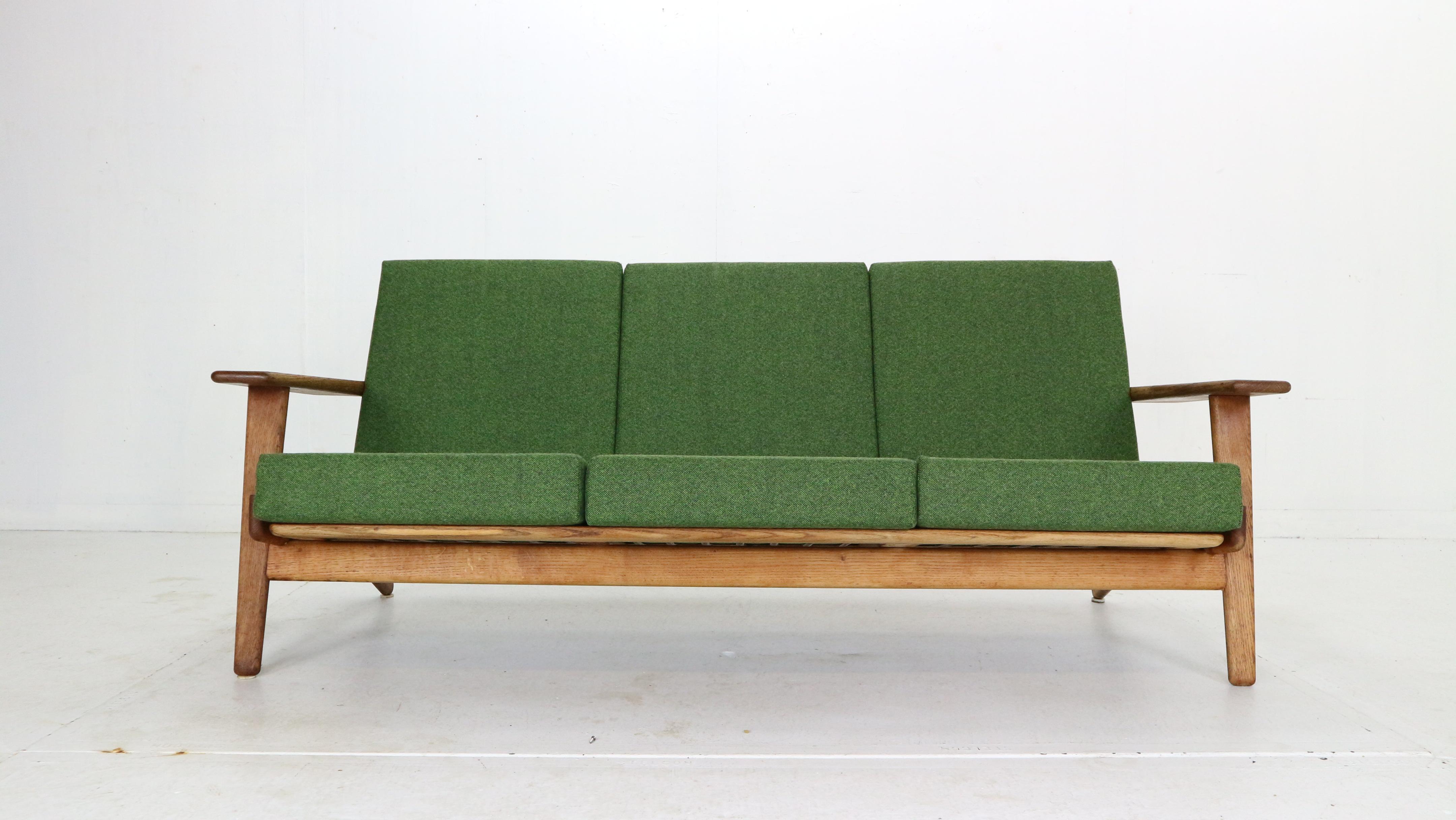 Scandinavian Modern period 3- seater sofa designed by Hans J. Wegner and manufactured by GETAMA in 1960's period, Denmark.

Solid oak sofa with elegant curving details and strong wide armrests, high backrests creates the most comfortable and
