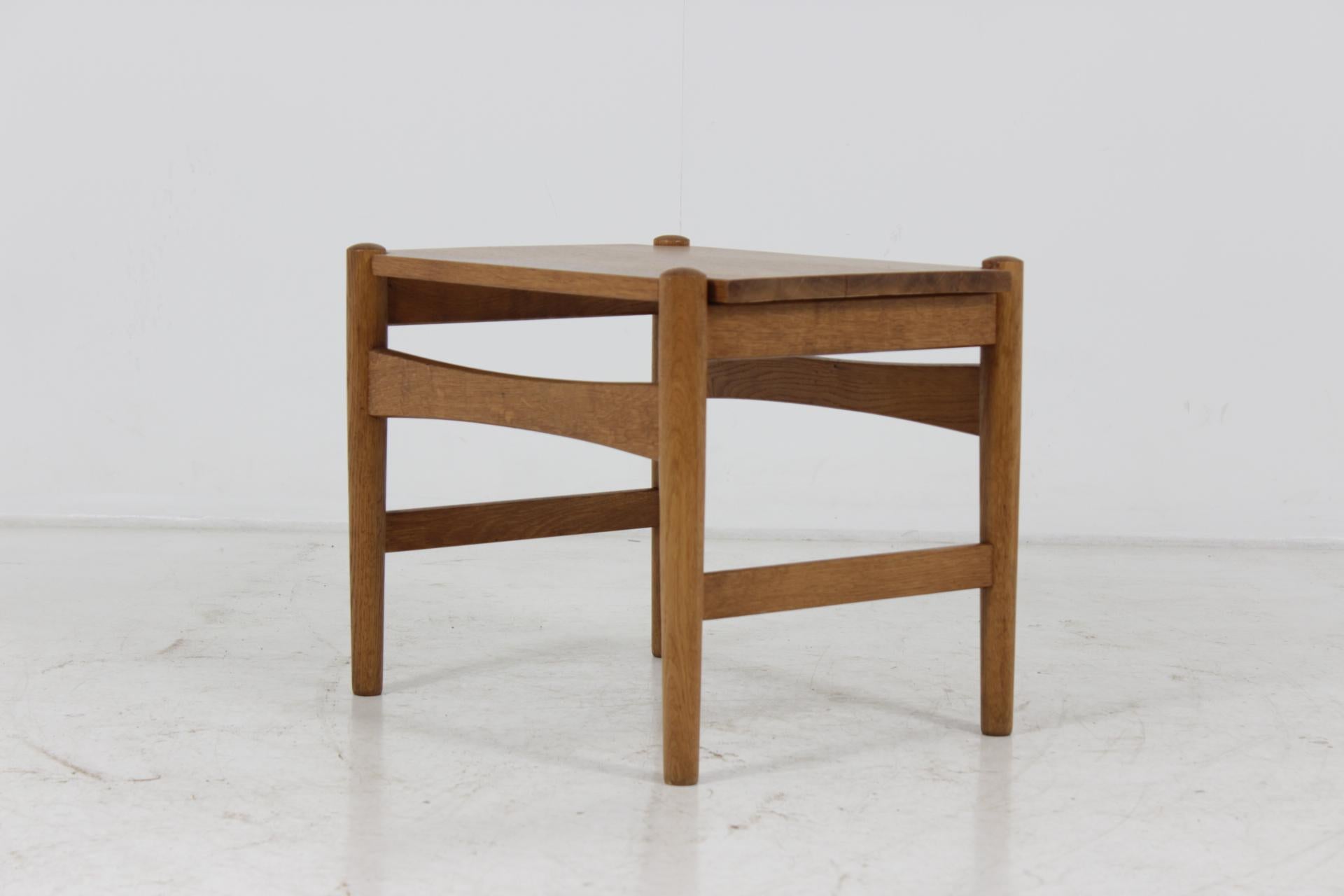 This midcentury oak side table, model AT 50, was designed by Hans J. Wegner for Andreas Tuck in the 1970s in Denmark. The Table is made of solid oak and features one removable plate. Carefully refurbished.