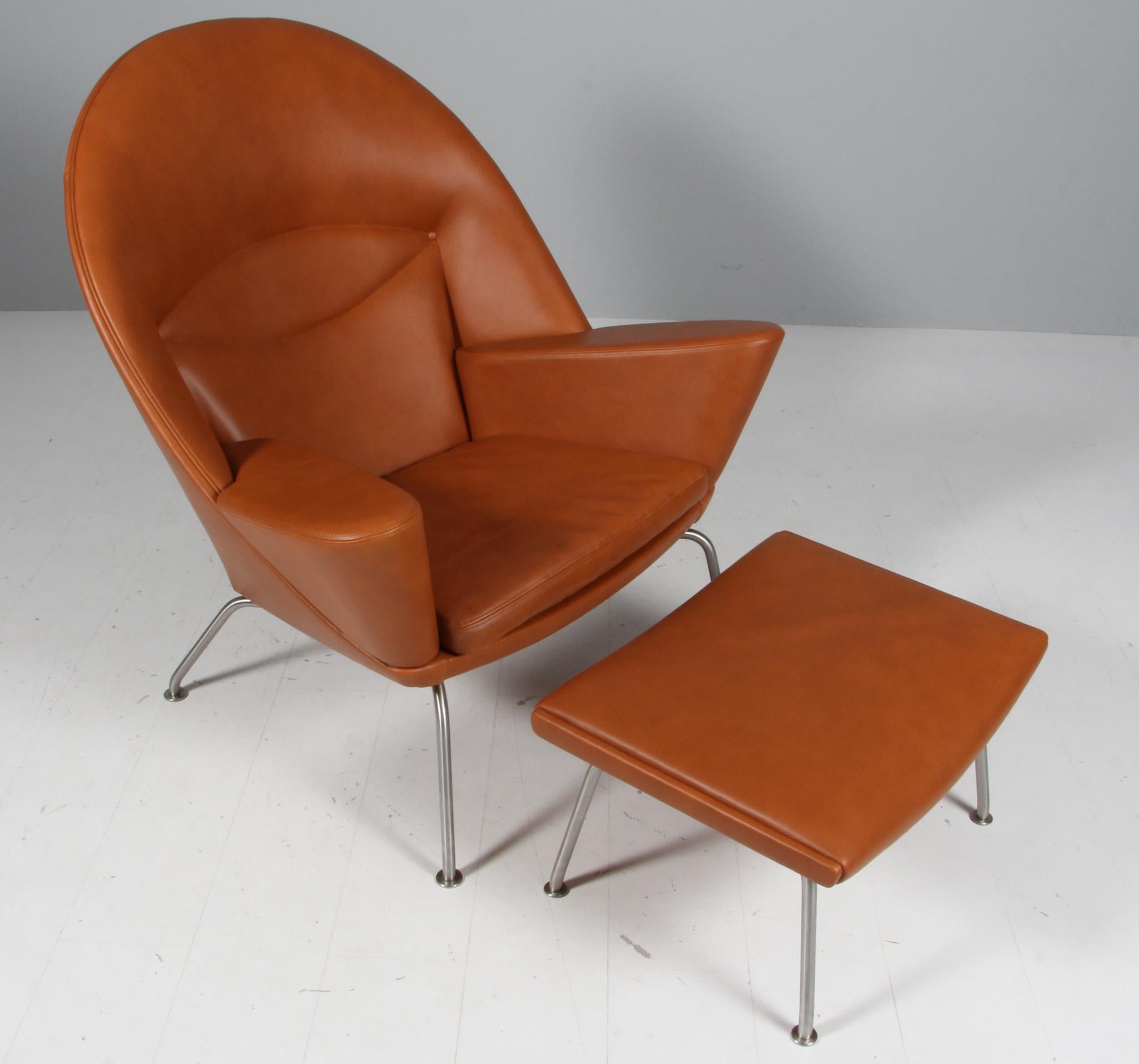 Hans J. Wegner lounge chair and ottoman in walnut elegance full grain aniline leather.

Legs of brushed stainless steel.

Model Oculus, made by Carl Hansen.