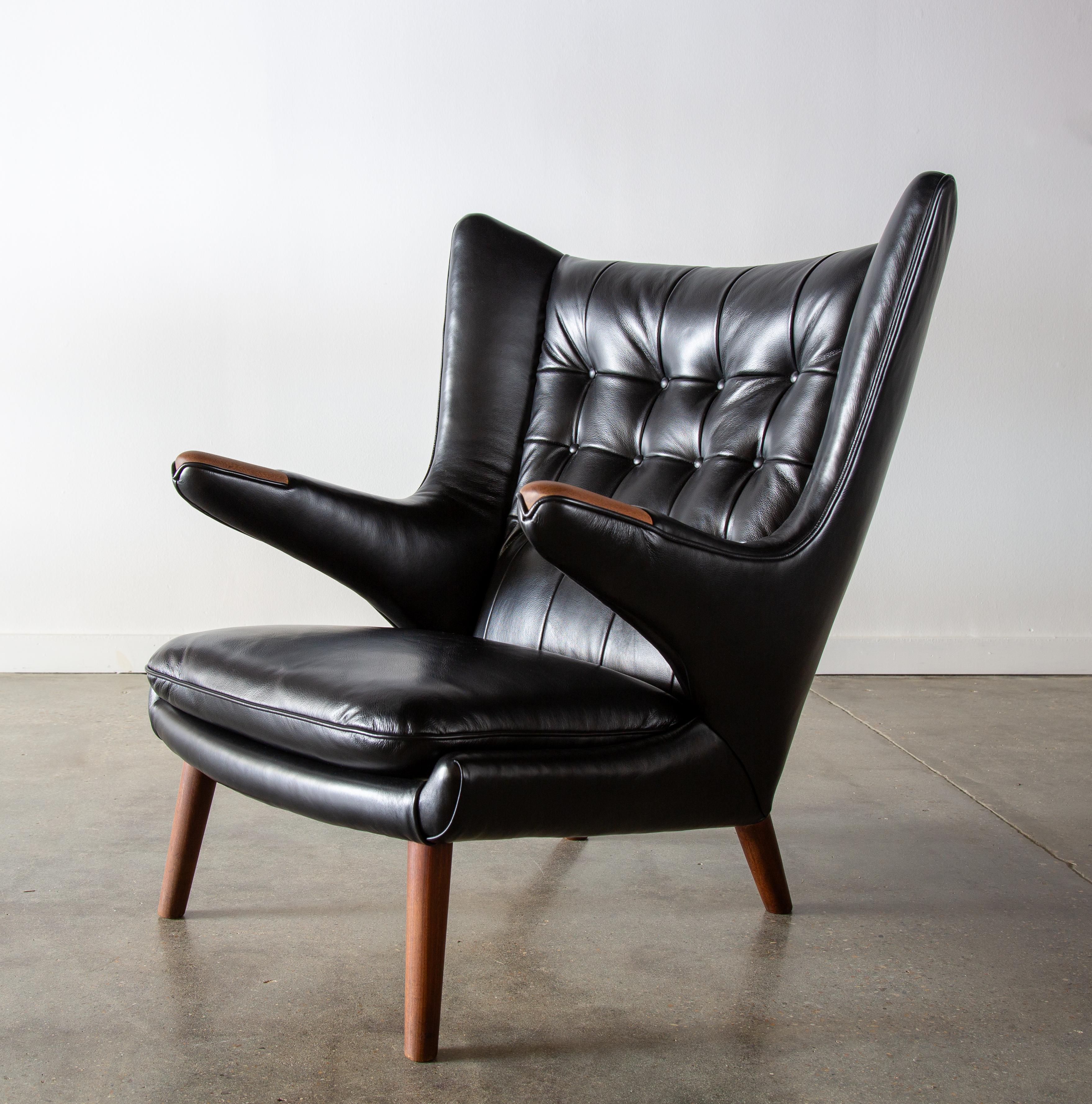 An original AP19 “Papa bear” chair designed by Hans J. Wegner for A.P. Stolen, designed in 1951 and made in Denmark.  This example with new black leather and featuring teak legs and teak paws. Retaining its original ap stolen stamp with the designer