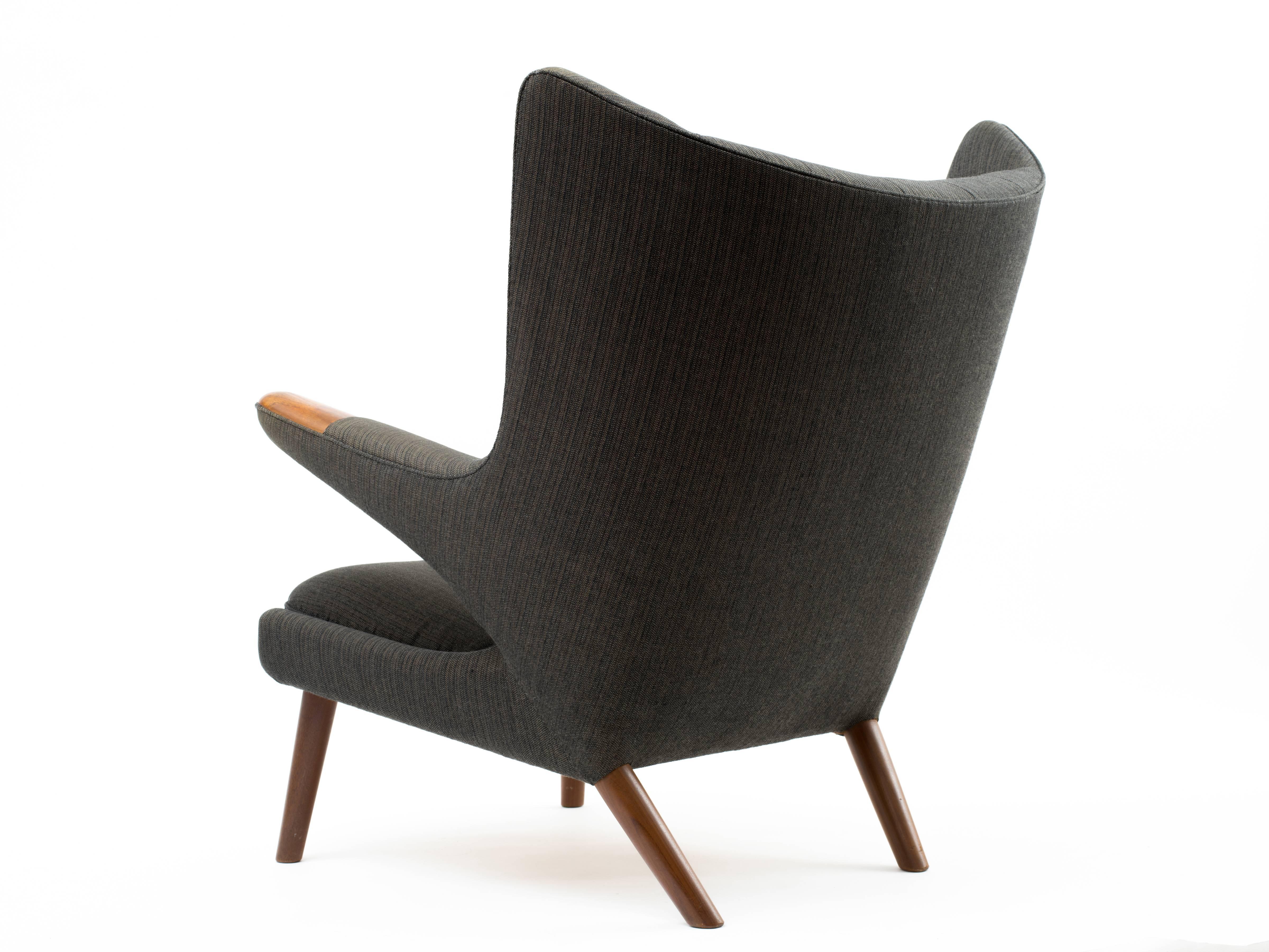 A Papa Bear chair, designed by Hans Wegner for AP Stolen in 1951. This example dates to circa 1959 and retains its original charcoal wool upholstery with one of the original extra backrest buttons still sewn behind the seat. Fabric has been expertly