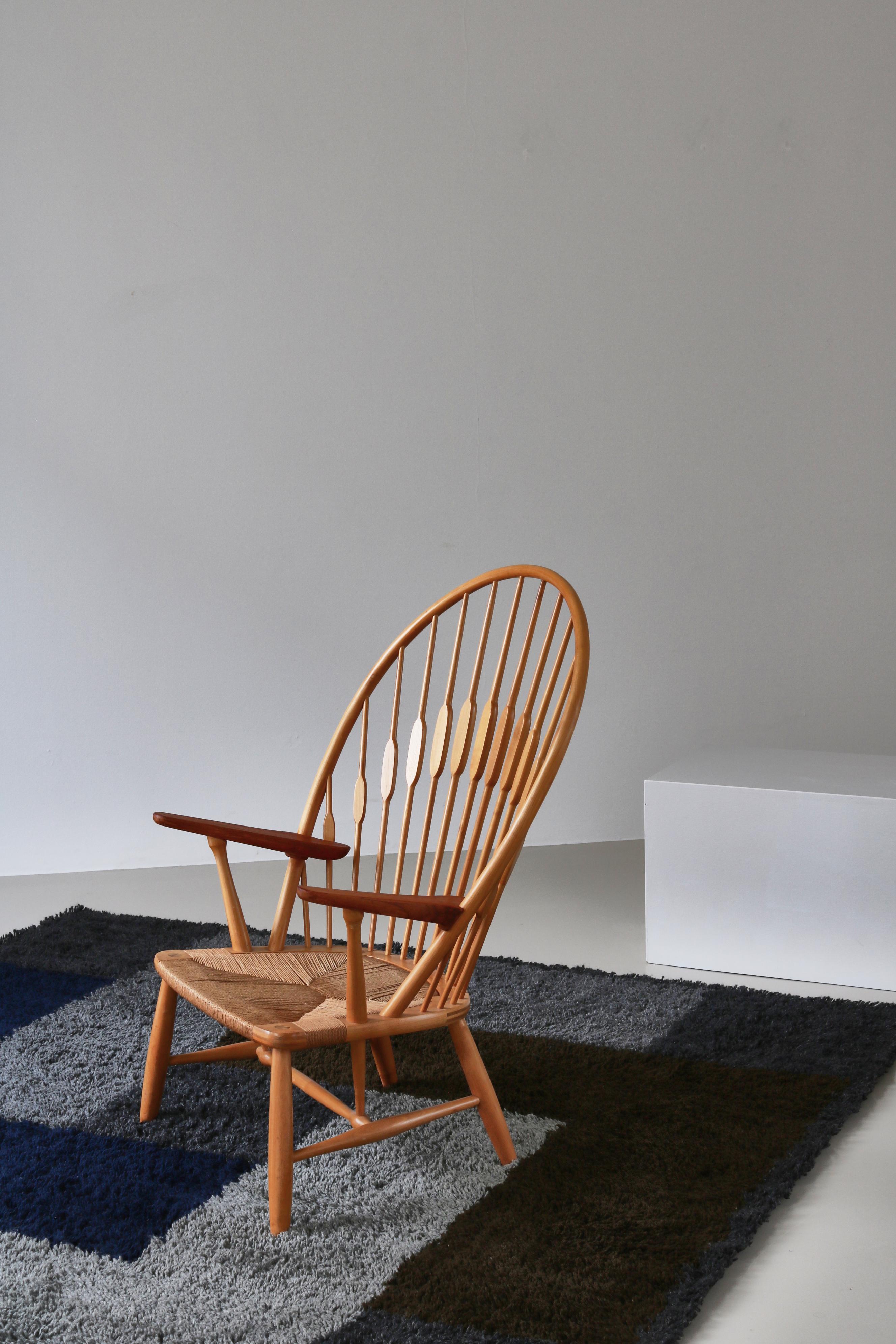 Chaise Peacock de Hans J. Wegner en frêne et teck, exécutée par l'ébéniste Johannes Hansen dans les années 1960. Ce bel exemple de la chaise emblématique de style Windsor de Hans J. Wegner conserve l'Icone d'origine et porte le marquage de brûlure