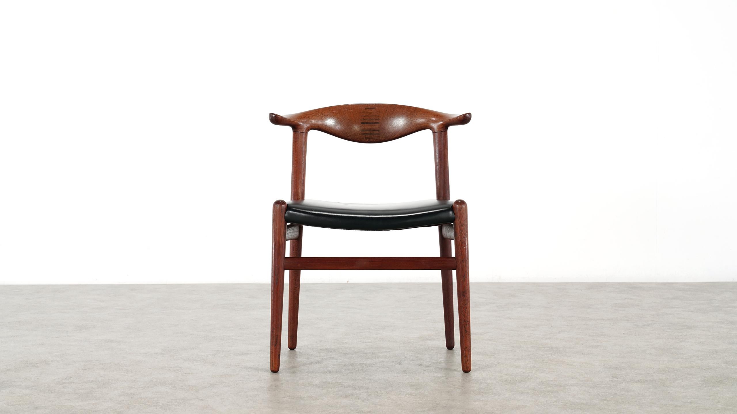 The iconic Cowhorn chair was designed in 1952 by Hans J Wegner in close dialog with master cabinetmaker Johannes
Hansen.

This chair is in original condition and shows a fine patina form the use over many years. Upholstery in black leather. Made