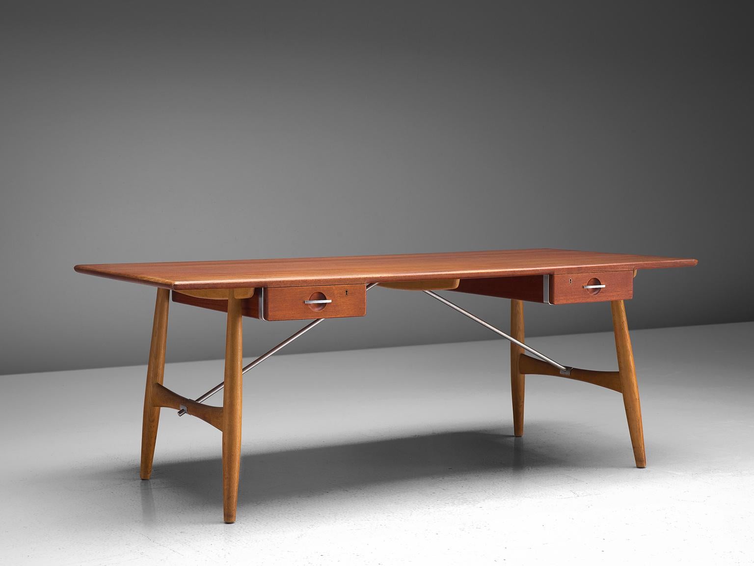 Hans J. Wegner for Johannes Hansen, desk JH571, teak, oak and metal, Denmark, 1953

Wegner designed the JH571 desk in 1953. It features a rectangular tabletop, beneath hanging two drawers with keywhole on each side. Two paired legs on the short side