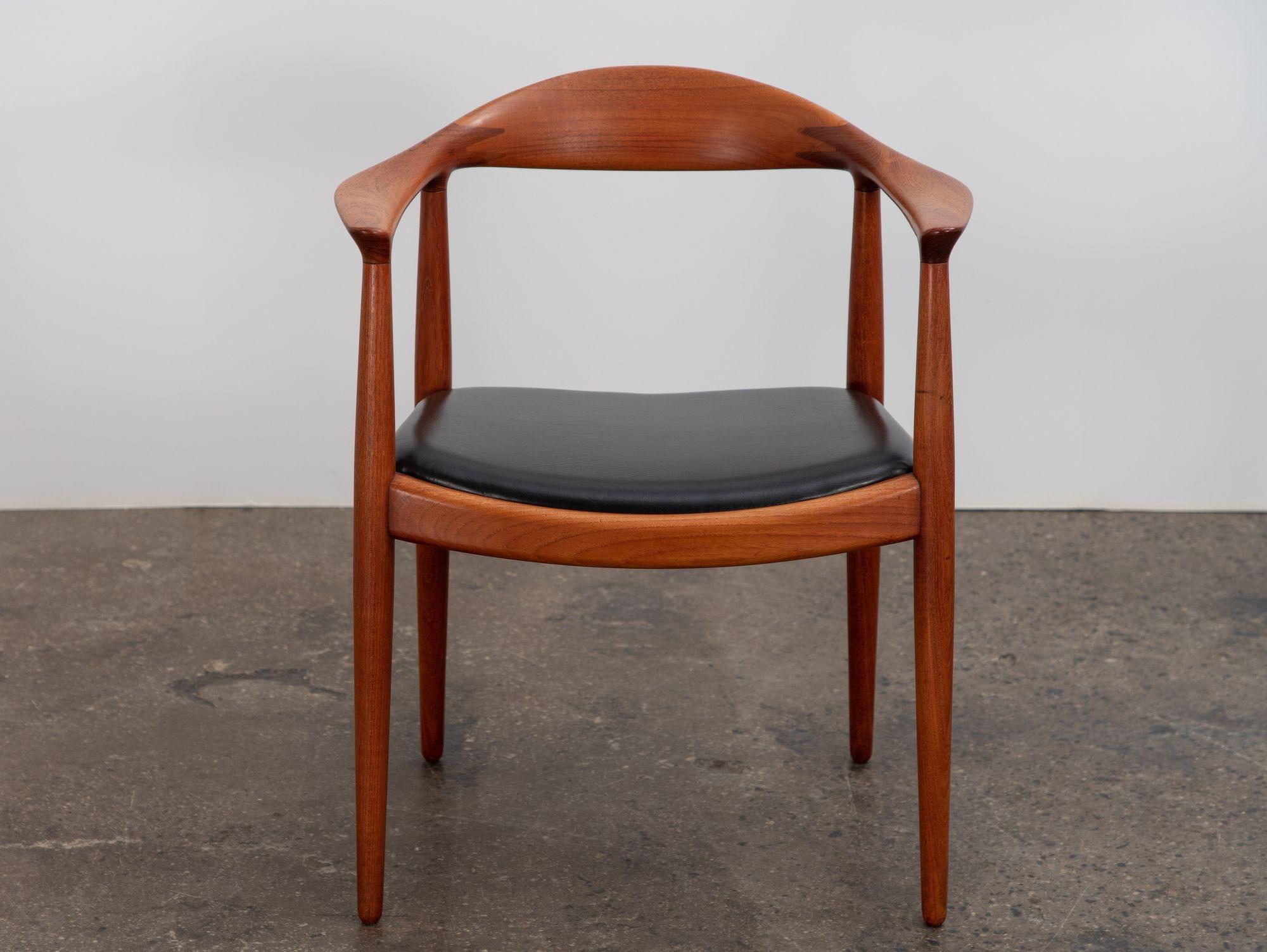 An original model JH-503 round armchair in teak and leather, designed by Hans J. Wegner for Johannes Hanse. Sculptural teak frame has been gently polished and retains lovely patina. Seats are shown in nicely aged black leather. Chair bears the