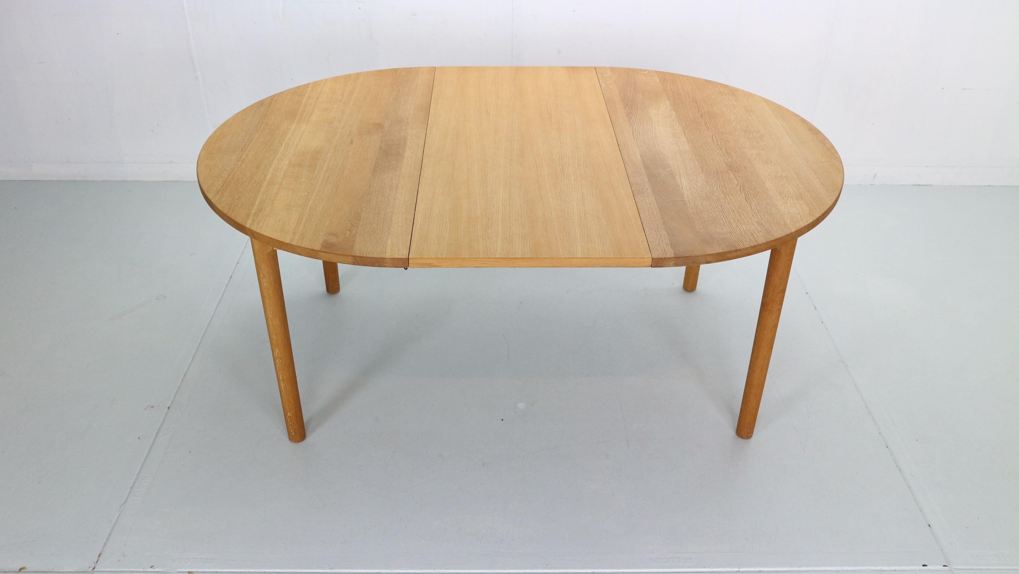 Scandinavian modern period dining table designed by hans j. Wegner and manufactured for ry mobler in 1970s period, denmark. Made of oak wood. Round dinning table has an extension leave. Extended from 114cm to 164cm wide. The table is in a perfect