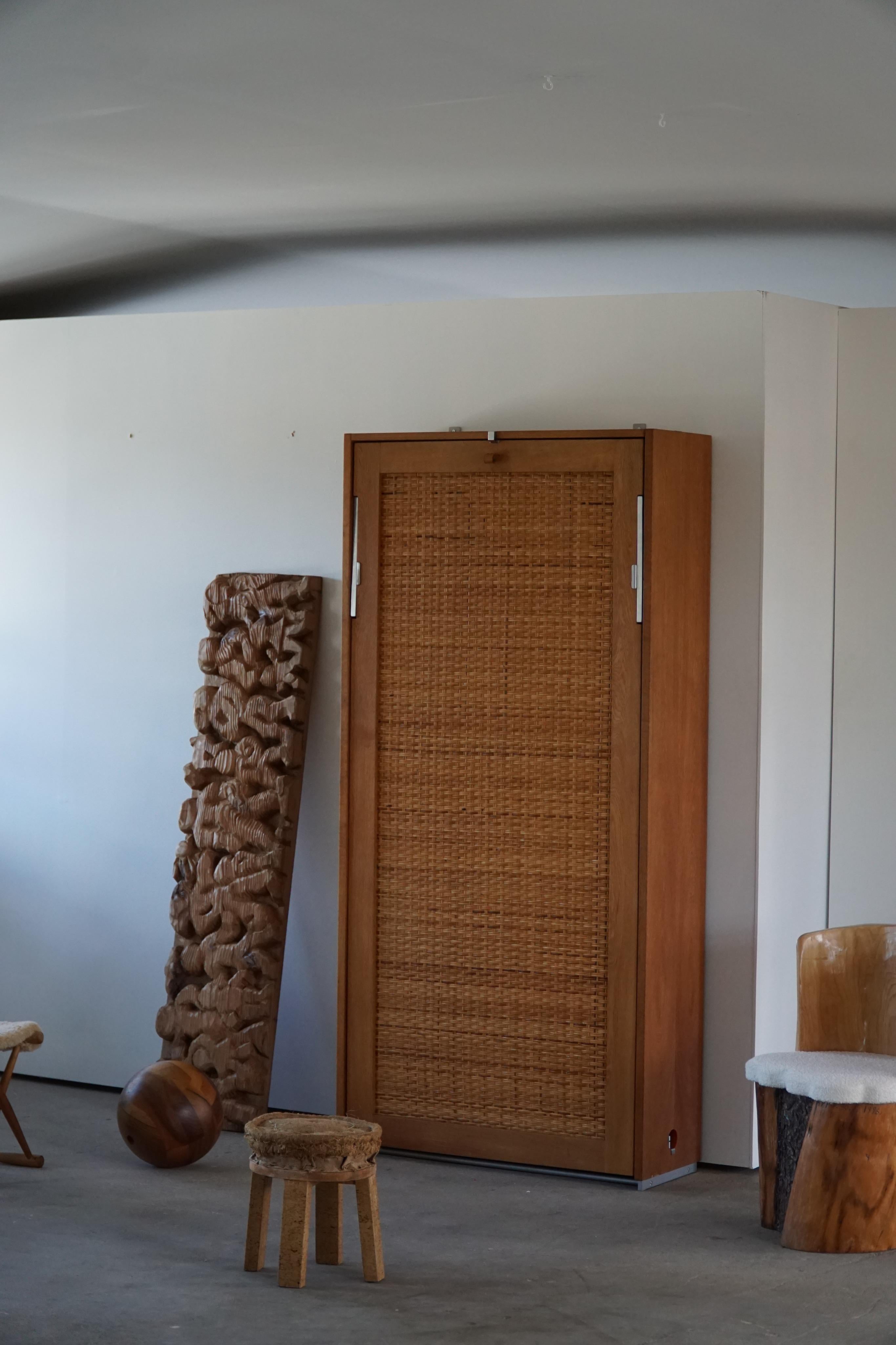 An elegant murphy bed with caned front designed, frame made in oak with some nice patinated leather handles. A classic Danish design, designed by Hans J. Wegner for RY møbler. Model 