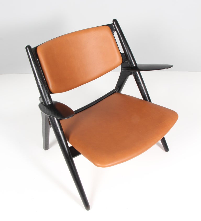 Hans J. Wegner sawbuk chair in later professional painted oak

Seat and back upholstered with tan aniline leather.

Model CH-28, made by Carl Hansen & Søn.