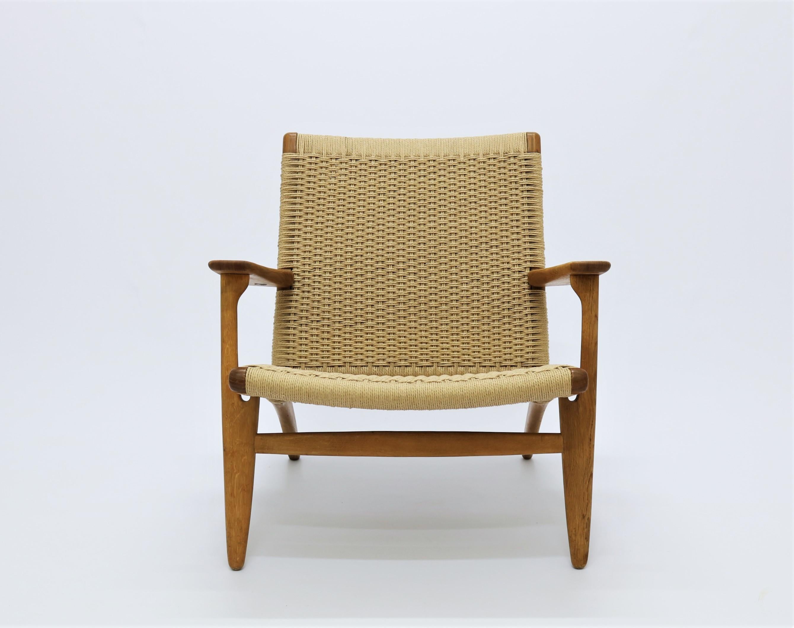 Beautiful vintage lounge chair model CH-25 by Danish Designer Hans J. Wegner for Carl Hansen & Son. This is a model from the very early production of the chair which and it has a perfect patina to the wood. It has been refinished with all new paper