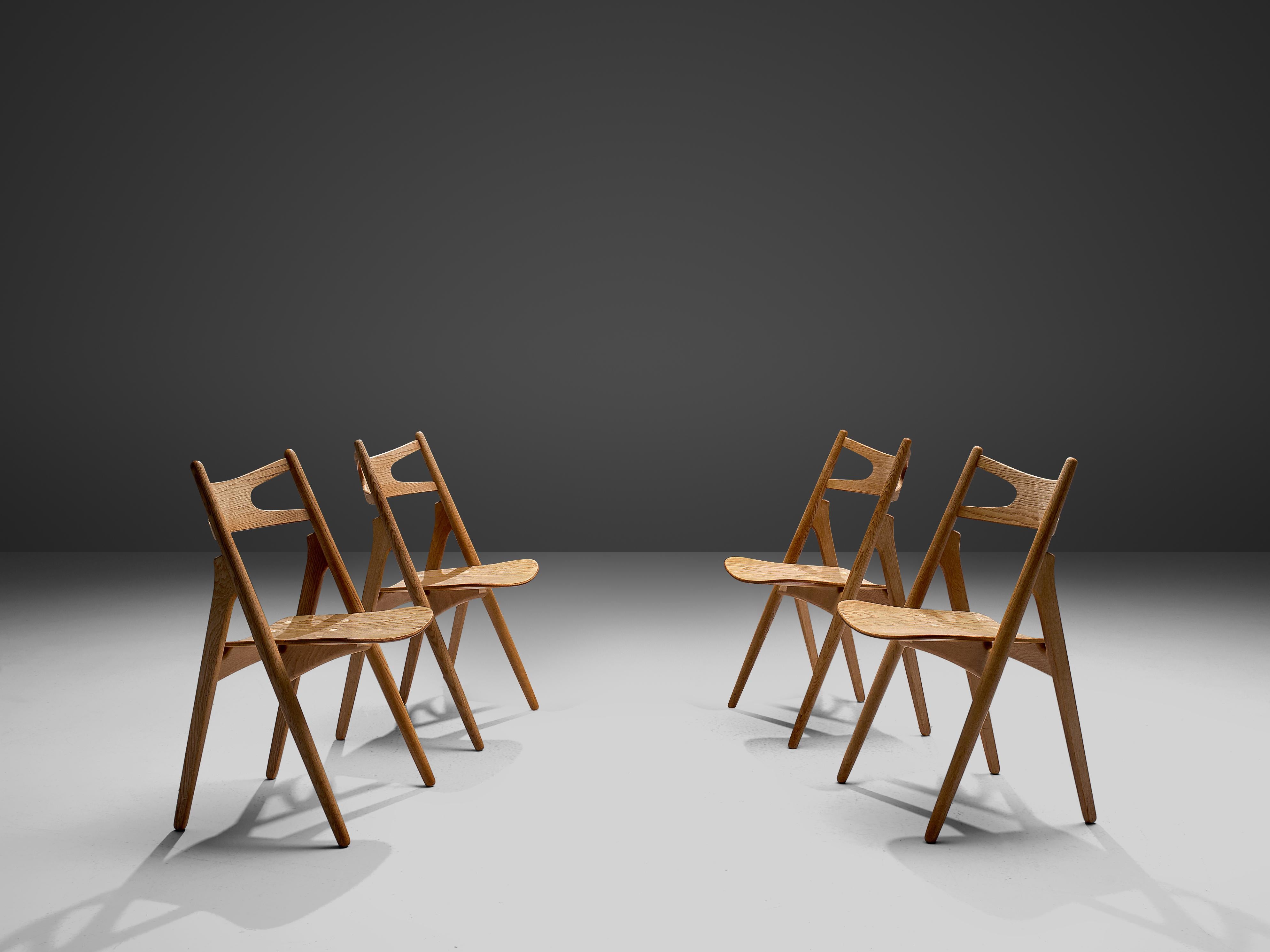 Hans J. Wegner for Carl Hansen & Søn, set of four 'Sawbuck' CH29 chairs, oak, Denmark, 1952.

This set of four chairs is designed by Hans J. Wegner for Carl Hansen. The chairs are defined by the V-shaped gaps in the back rest. The chair has a
