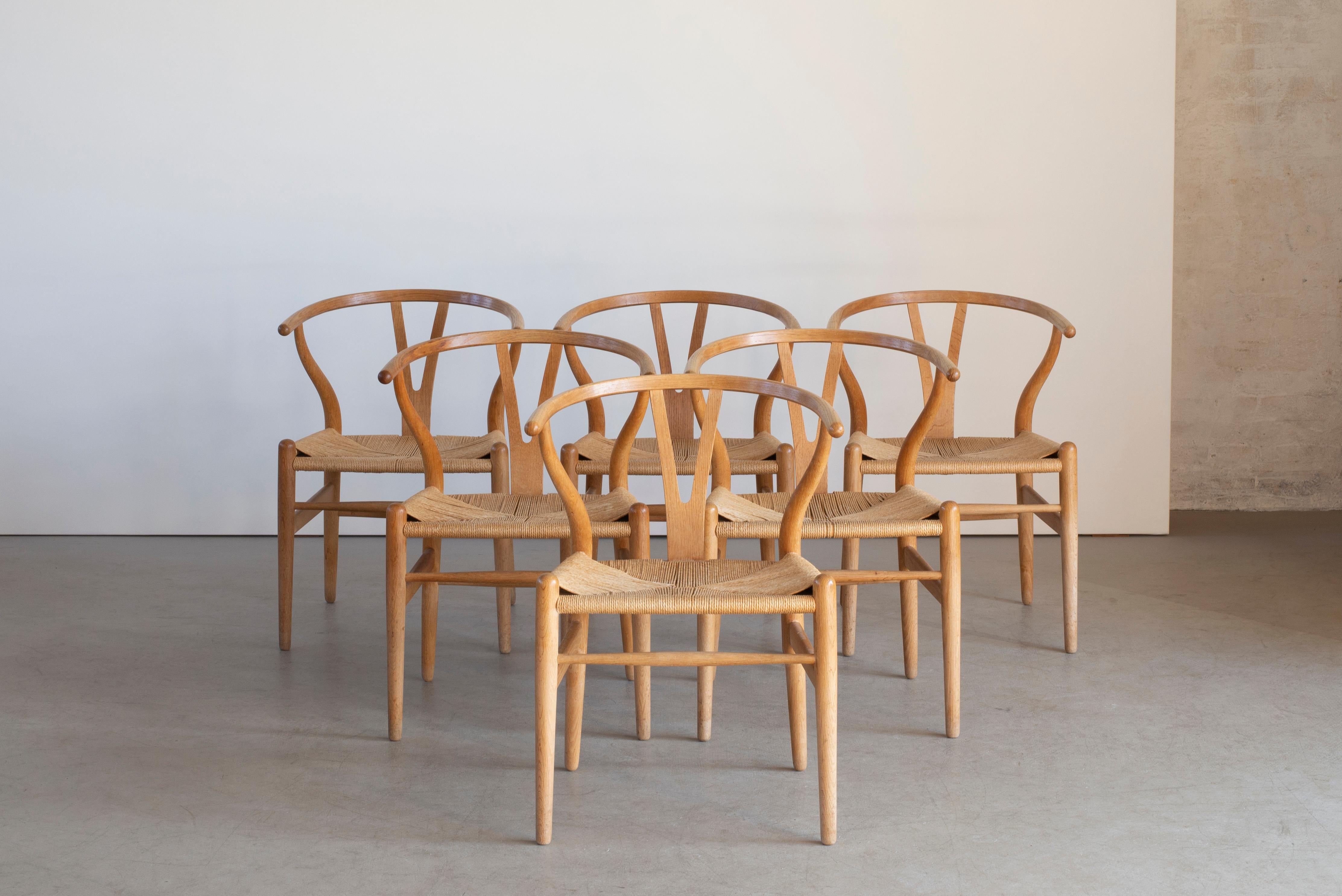 Hans J. Wegner “The Wishbone Chair”. Set of six armchairs of oak. Seat with woven papercord. CH 24. Designed 1949. Manufactured by Carl Hansen & Søn.