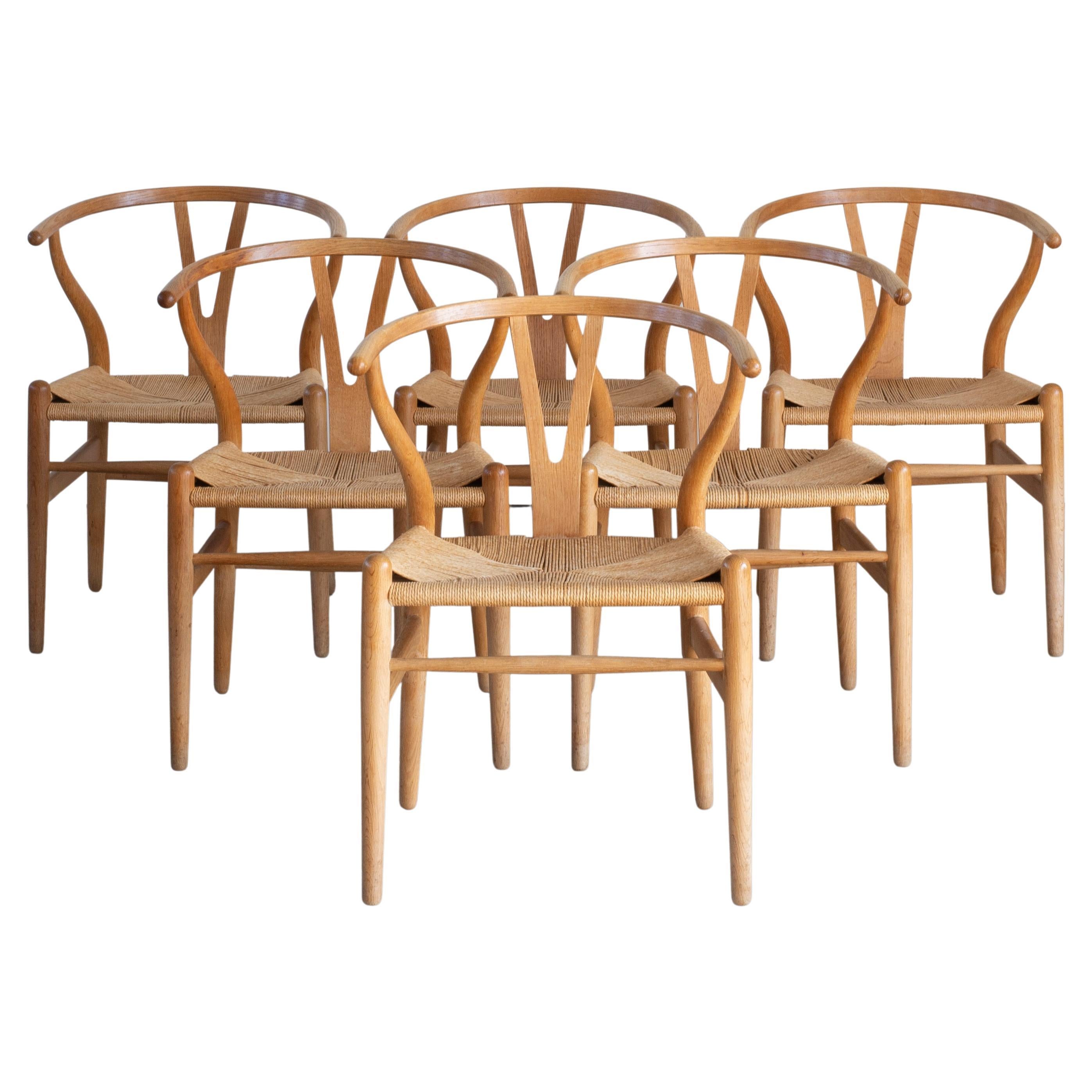 Hans J. Wegner Set of Six “Wishbone” Chairs in Oak For Sale