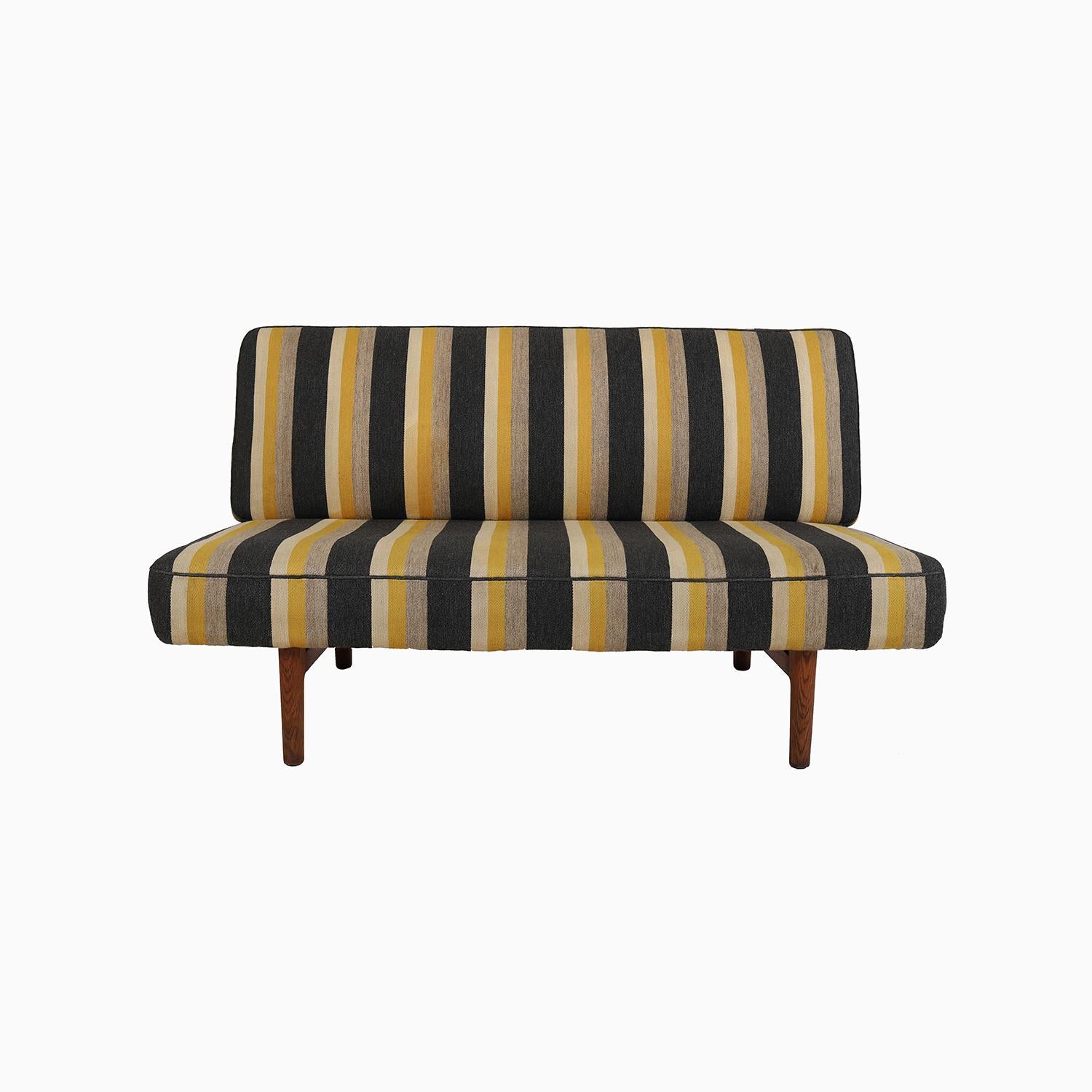 Este canapé de Hans J. Wegner está hecho de un robusto y bien envejecido roble blanco acabado al aceite.  Tiene un original tejido a rayas de lana de estambre en una franja de color carbón jaspeado, dos grises y una dorada.  El textil está en