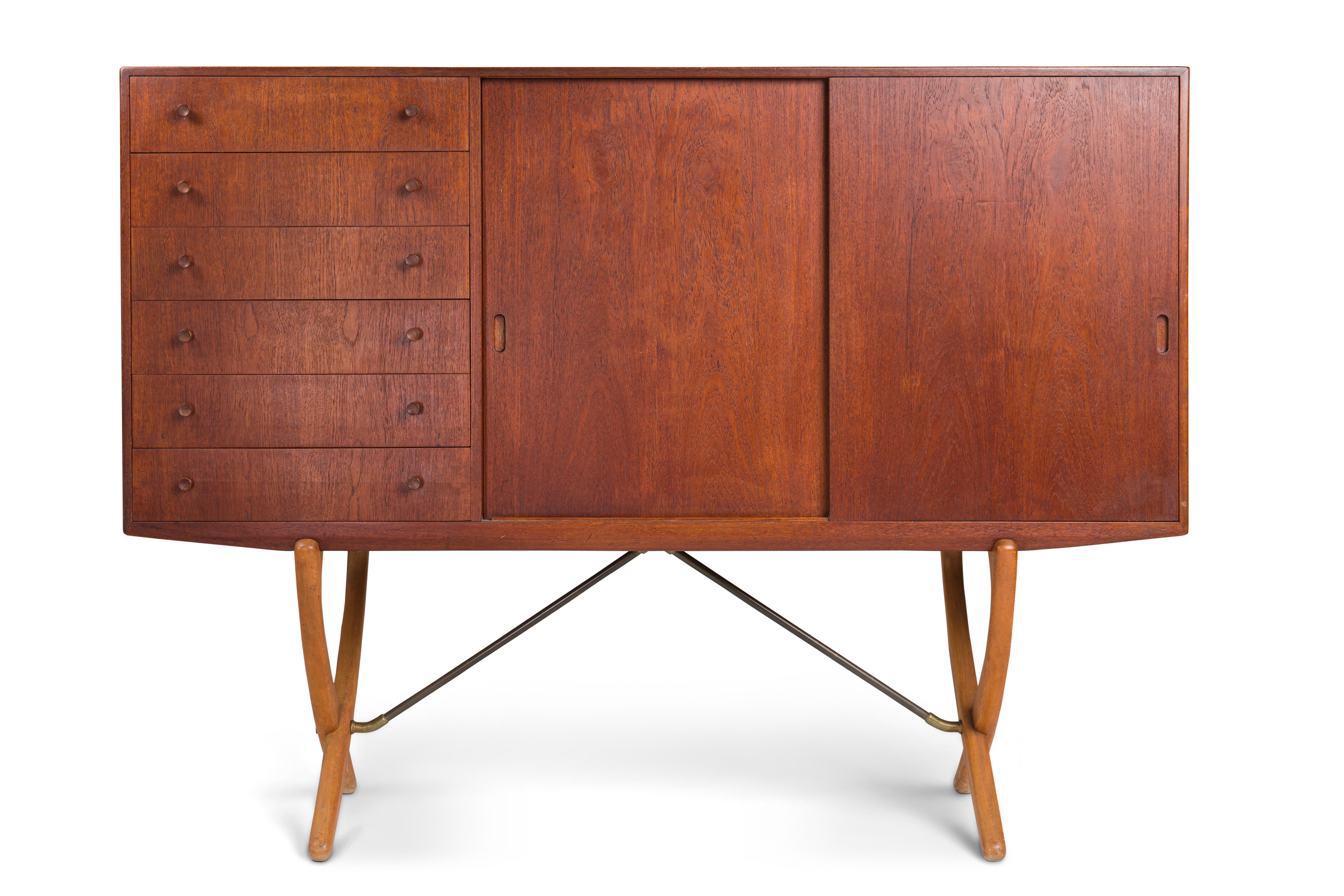 Hans J. Wegner for Carl Hansen & Søn.
Model CH304 sideboard, teak and front with six drawers and two sliding doors enclosing shelves and sliding trays, sabre-formed crossed legs in beech with brass struts.
Shrinkage crack by one leg and repair to