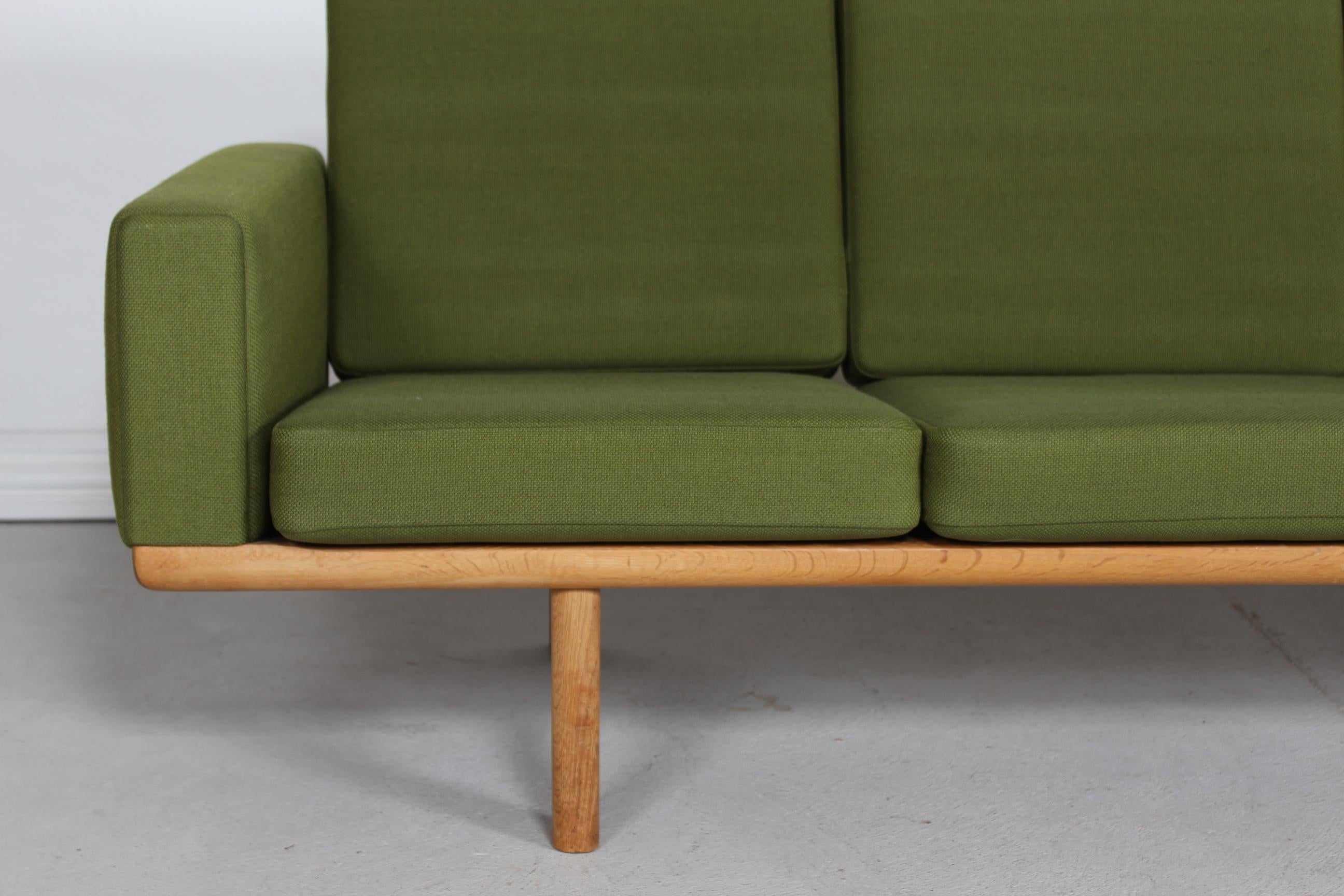 Hans J. Wegner (1914-2007) 4-seater sofa GE 236 / 4.
This sofa is manufactured in the 1970s of solid oak.
The cushions are upholstred with green wool fabric.

A piece of furniture that show beautiful patina after normal use with the original