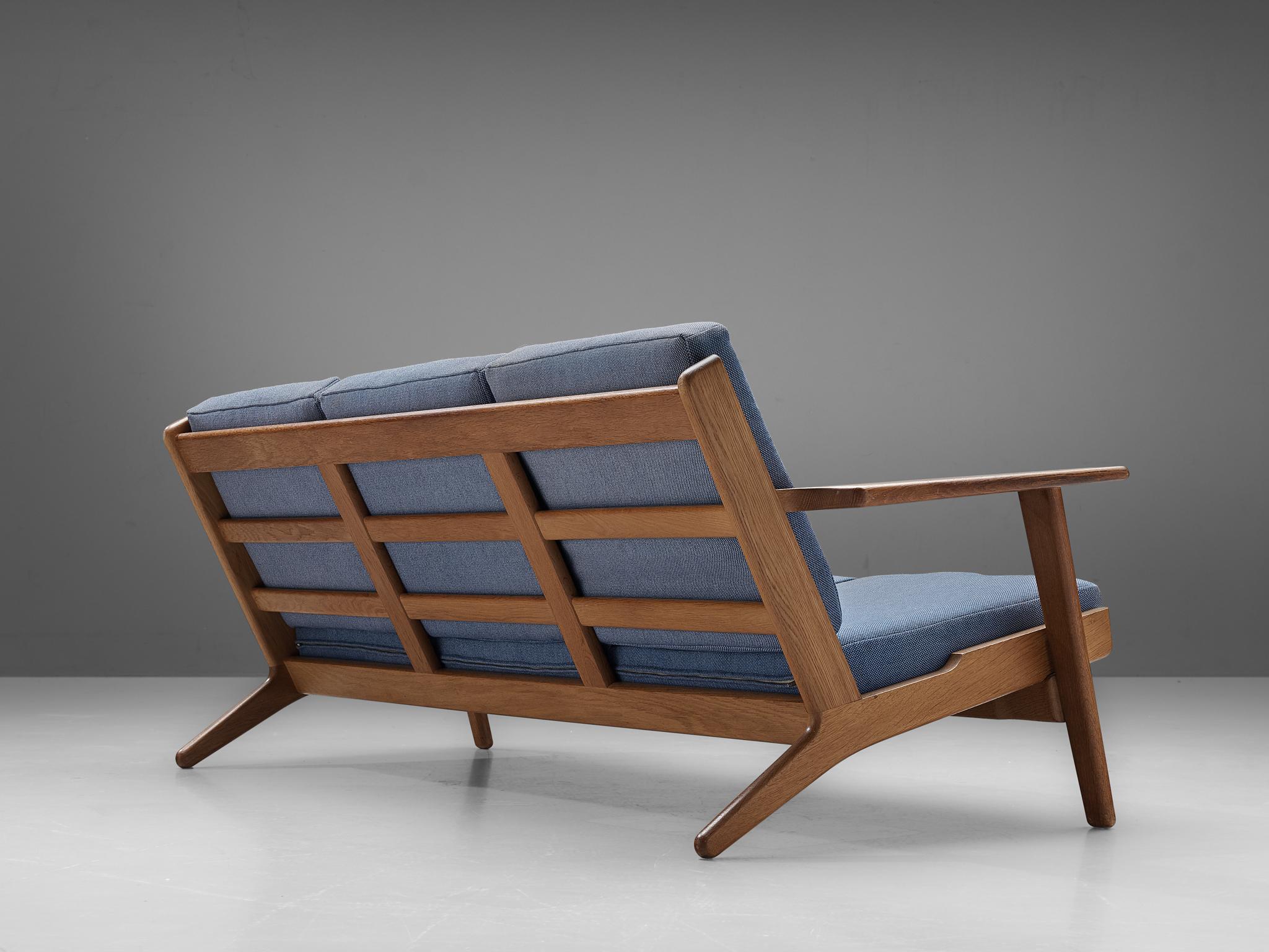 Hans J. Wegner, three-seat sofa, model GE290 for Getama, oak, fabric upholstery, Denmark, 1950s

Hans J. Wegner designed the GE290 with an inclined seating and backrest which created a comfortable sofa. Besides loose cushions increase the comfort.