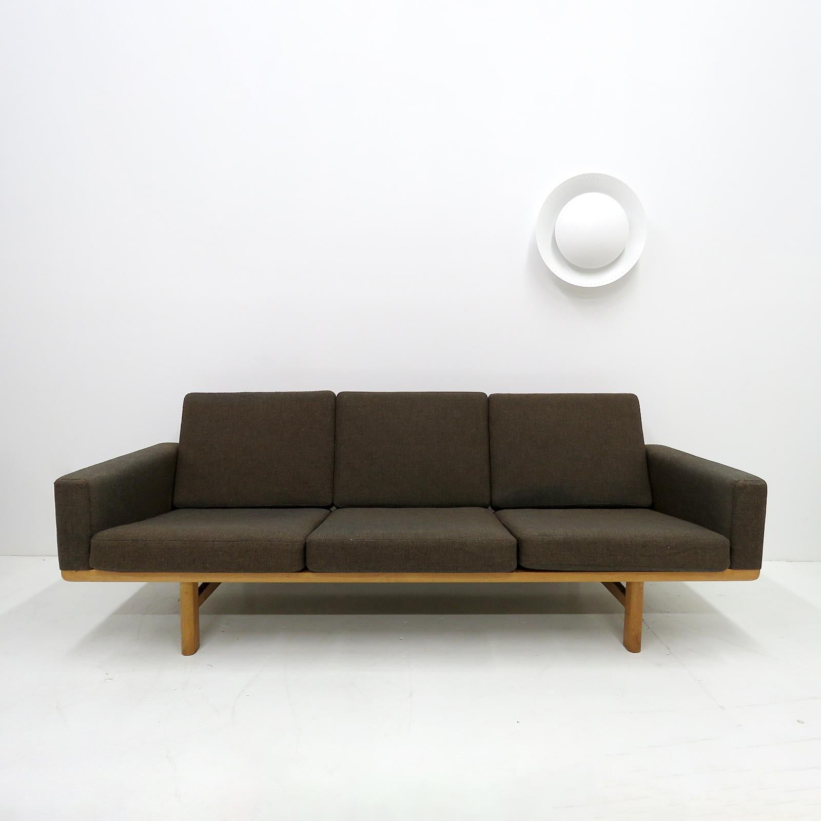 wonderful 1950s Danish three-seat sofa, model GE236/3 designed by Hans J. Wegner for GETAMA, solid oak frame with nice patina and original spring loaded cushions with grey/brown wool fabric, marked.