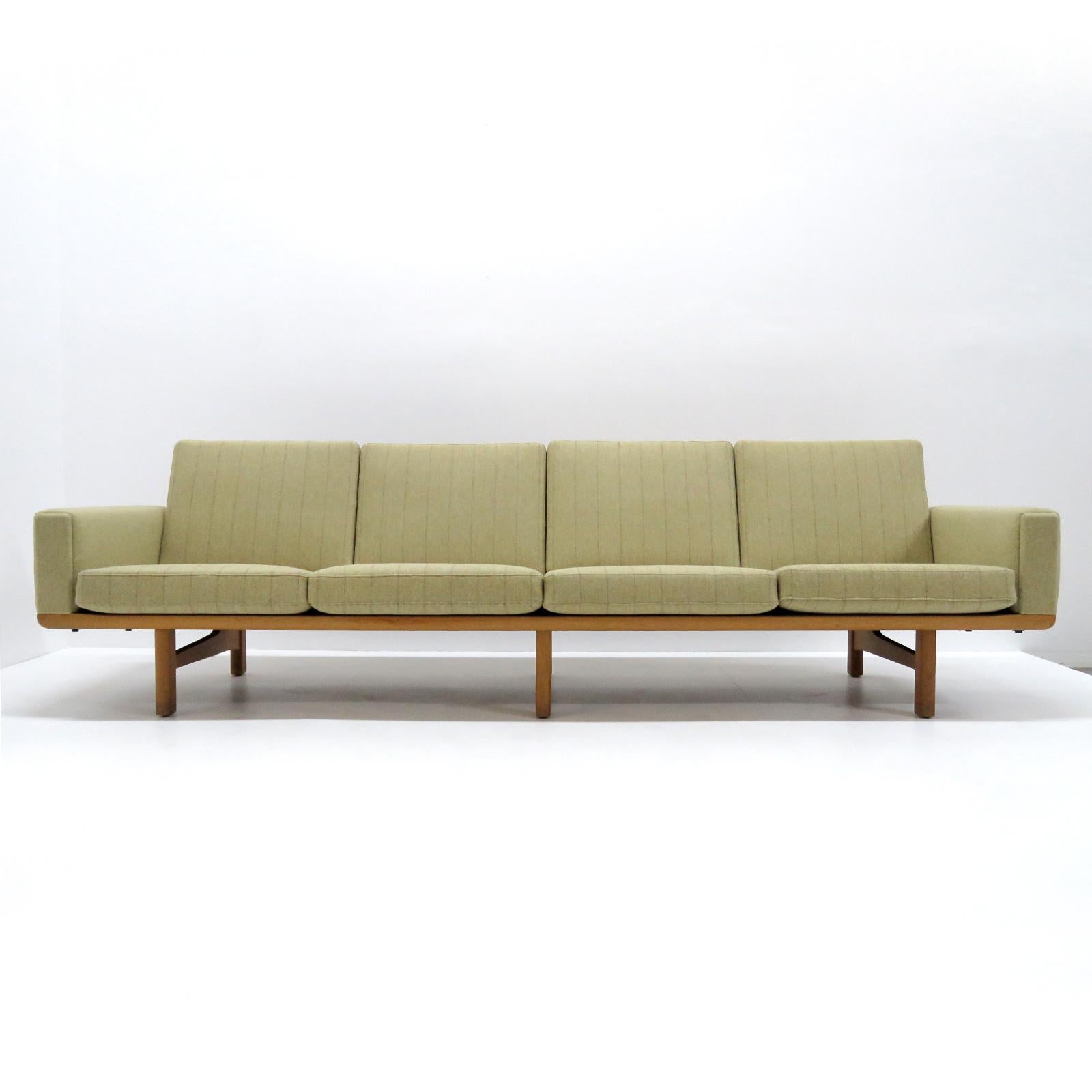 vintage 1950s Danish four-seat sofa, model GE236/4 designed by Hans J. Wegner for GETAMA, solid oak frame with nice patina and original cushions later reupholstered with light yellow-ish wool fabric with subtile stripes on the cushions, marked.