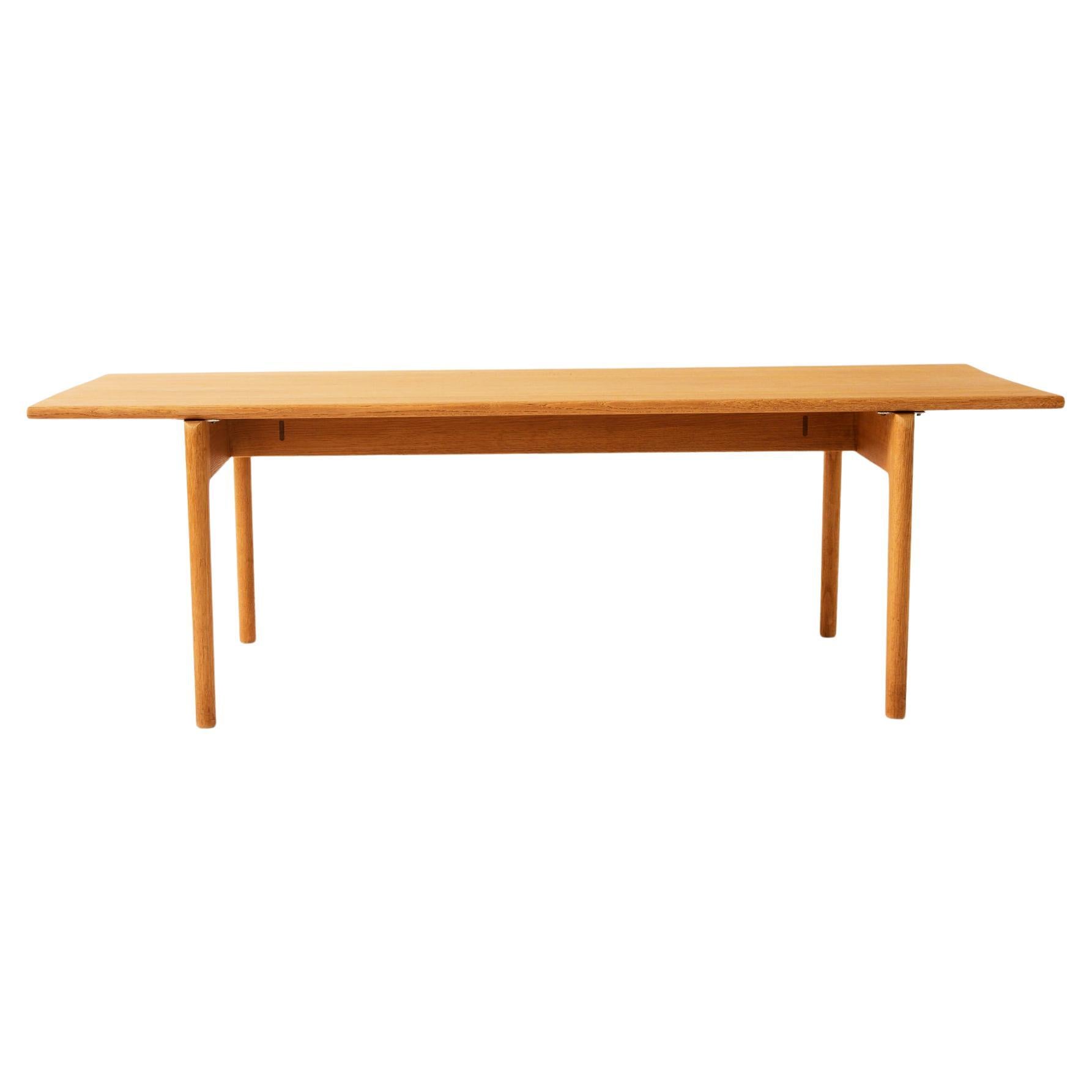 Hans J. Wegner's AT-15 rectangular solid oak coffee table is elegant and understated in its design. Made of solid oak and in very good condition. Makers mark is stamped on underside of table. Manufactured by Andreas Tuck, 1960's. 

Wegner was one