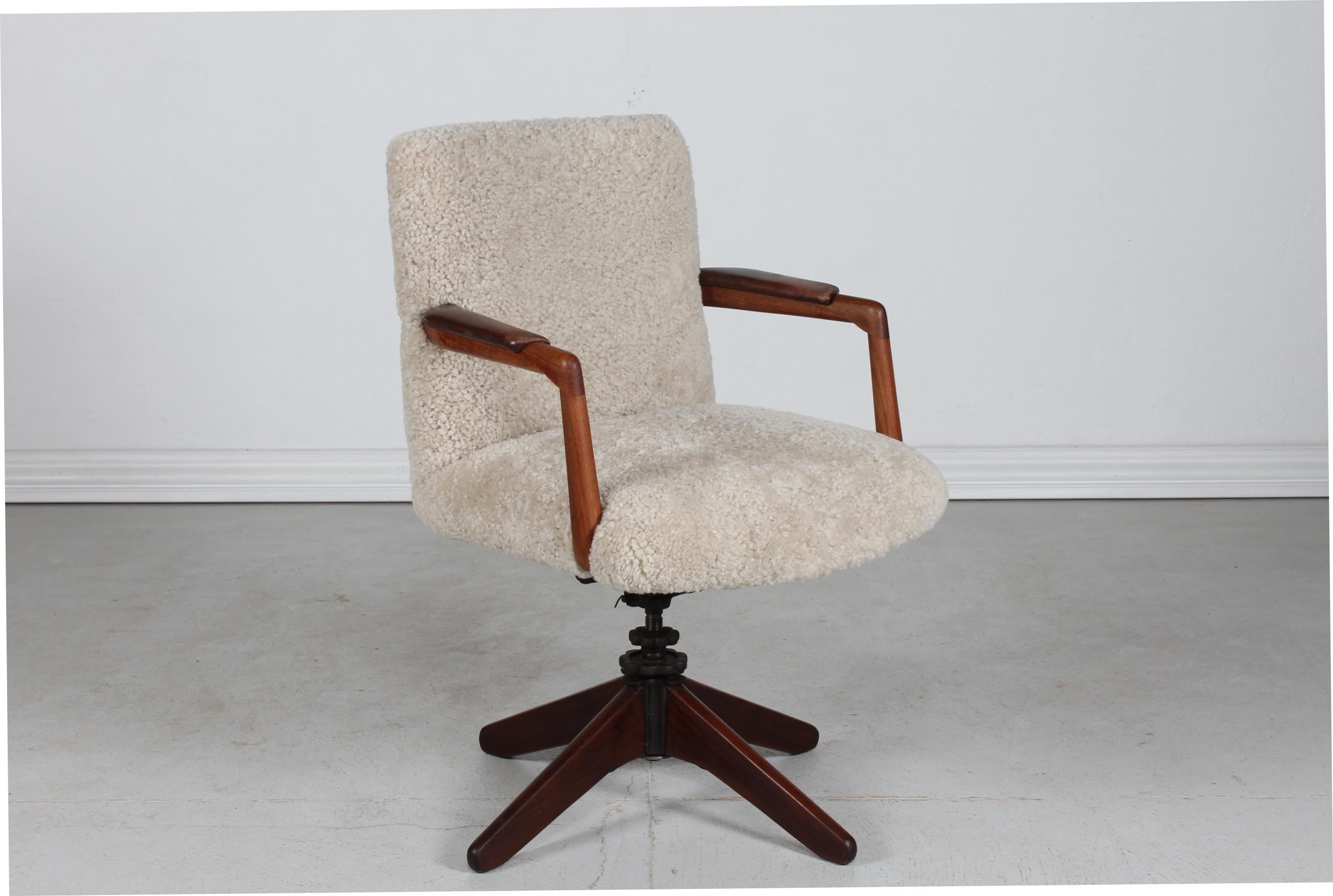 Hans J. Wegner style Vintage Danish swivel chair/office chair.
The teak armrests are upholstred with the original leather. 
The seat and backrest are reupholstered with new sheepskin. 

It is possible to adjust the angle of the seat - The Sheriff