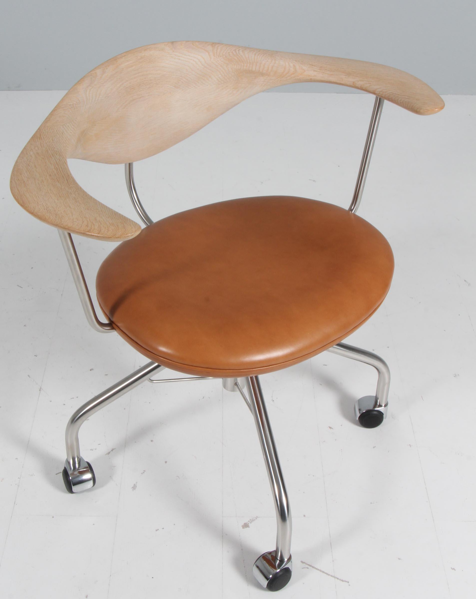 The iconic Hans J. Wegner Swivel chair with oak back and armrest. Seat of the highest quality Elegance leather from Arne Sørensen. 

Base of stainless steel.

Model PP502, made by PP Møbler. 