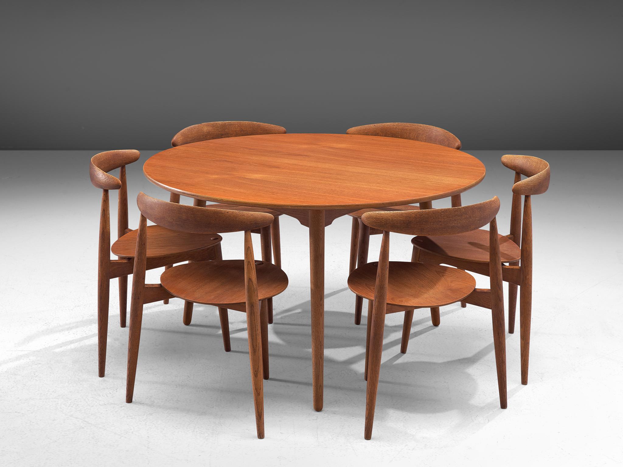 Hans J. Wegner for Fritz Hansen, set of 6 Heart chairs FH4103 and dining table, teak, Denmark, 1953.

This dining set, consisting of a round dining table and six dining chairs, is designed by Hans Wegner in 1952. The chairs are designed to take up