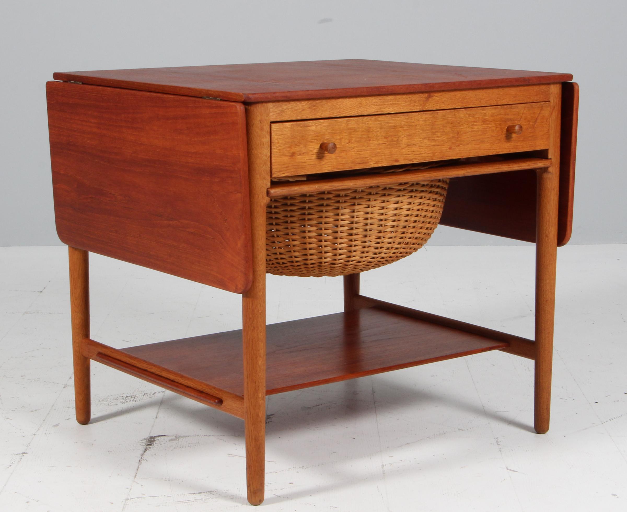 Mesa de costura AT-33 de teca y caña de Hans J. Wegner producida por Andreas Tuck, Dinamarca, hacia 1960
2 hojas abatibles, cesta de costura extraíble, cajón con separador, almacenaje y husillos
Estado impecable, firmado
Medidas: A 60 x L 67 (+ 2