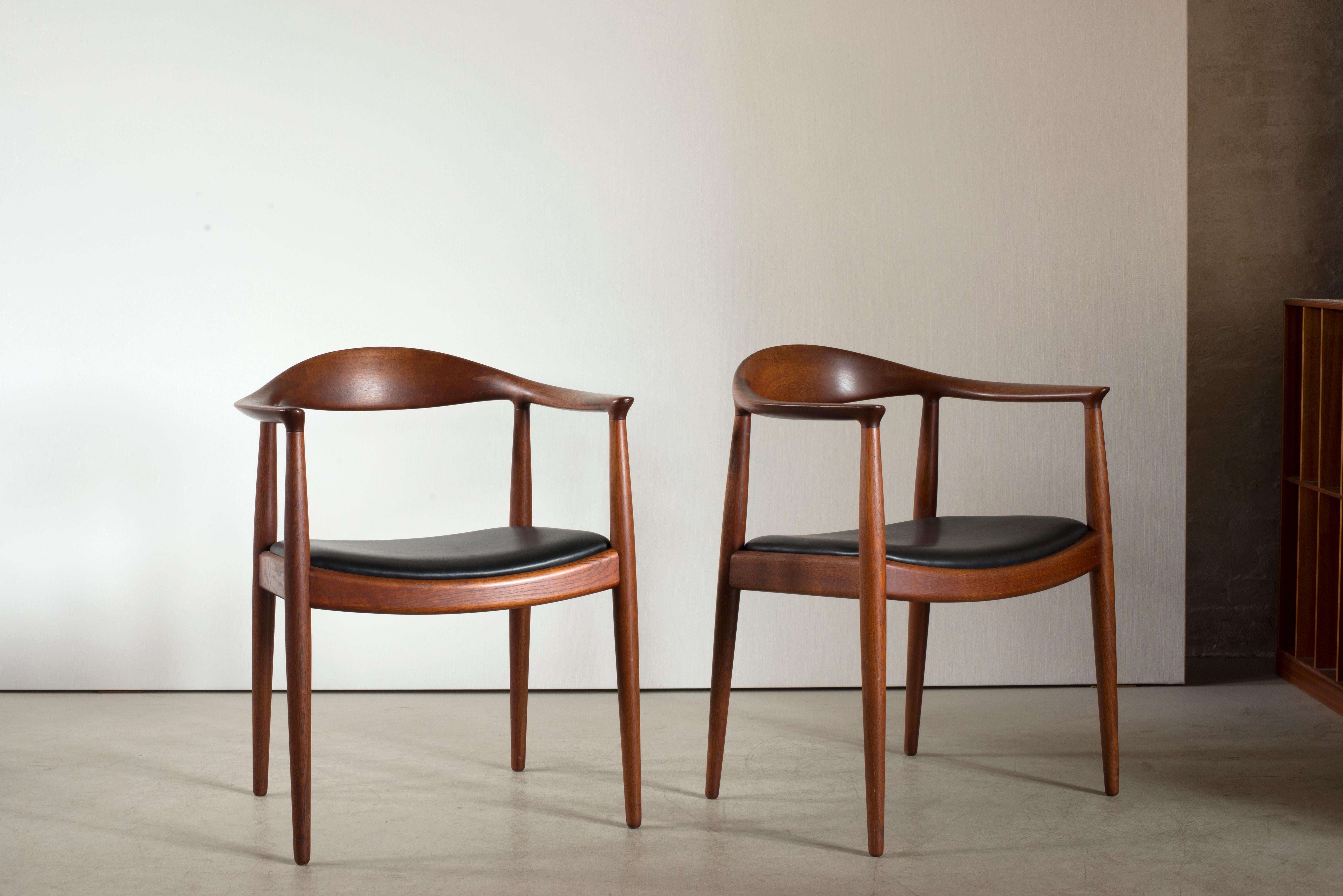 Hans J. Wegner model JH503 in teak. Seat upholstered with black leather. Executed by Johannes Hansen, Copenhagen, Denmark.