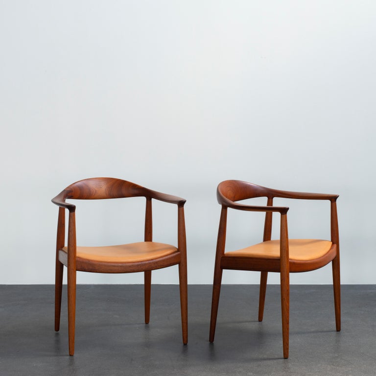 Hans J. Wegner pair of model JH503 in teak. Seat upholstered with vegetable tanned leather. Executed by Johannes Hansen, Copenhagen, Denmark.
