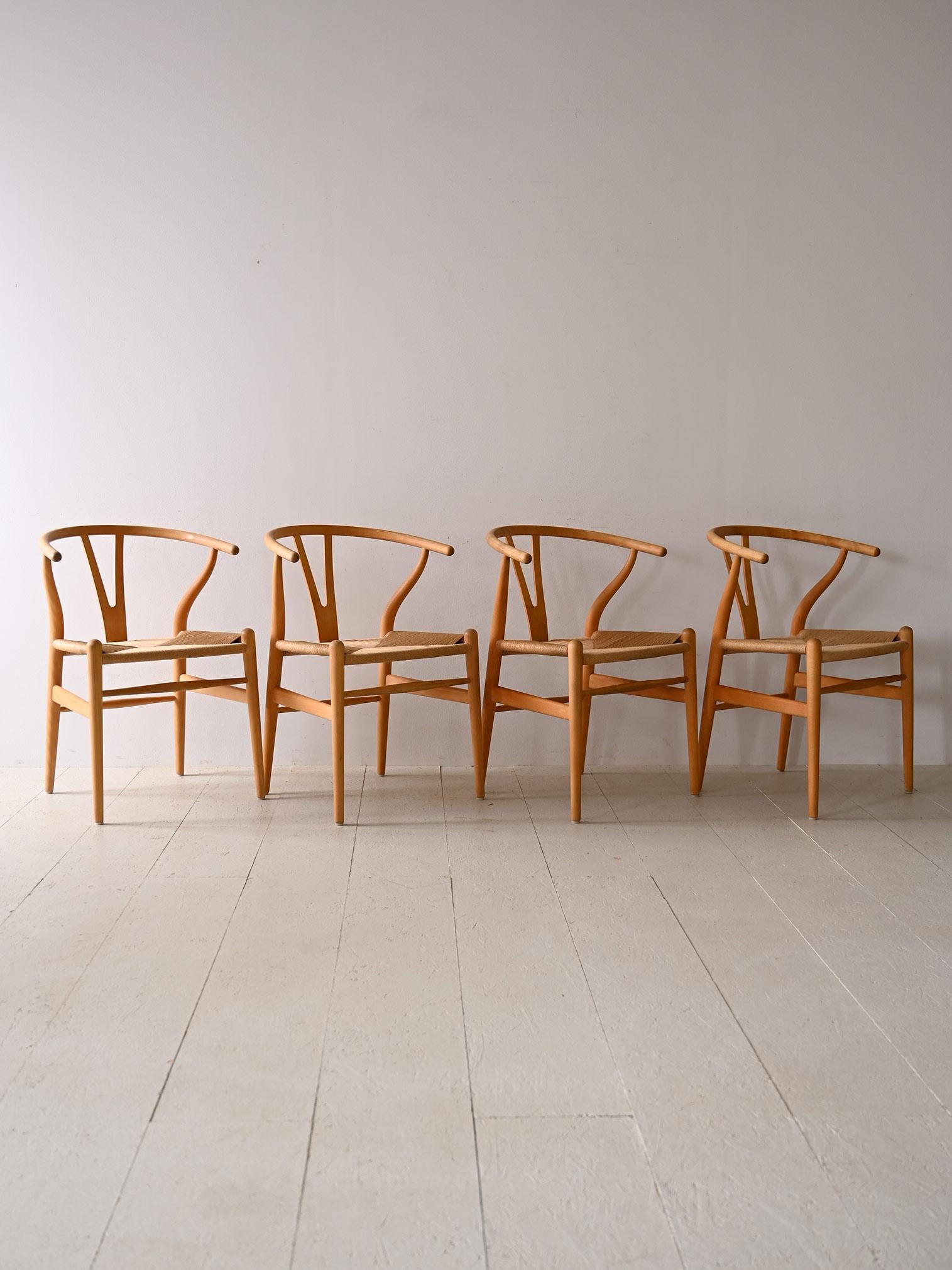 Set di 4 sedie modello 'Wishbone chair' di Hans J. Wegner con cuscini in pelle CH24 : Un capolavoro di design danese di Hans J. Wegner per Carl Hansen & Søn. Les sièges CH24, mieux connus sous le nom de Wishbone Chair, représentent le design