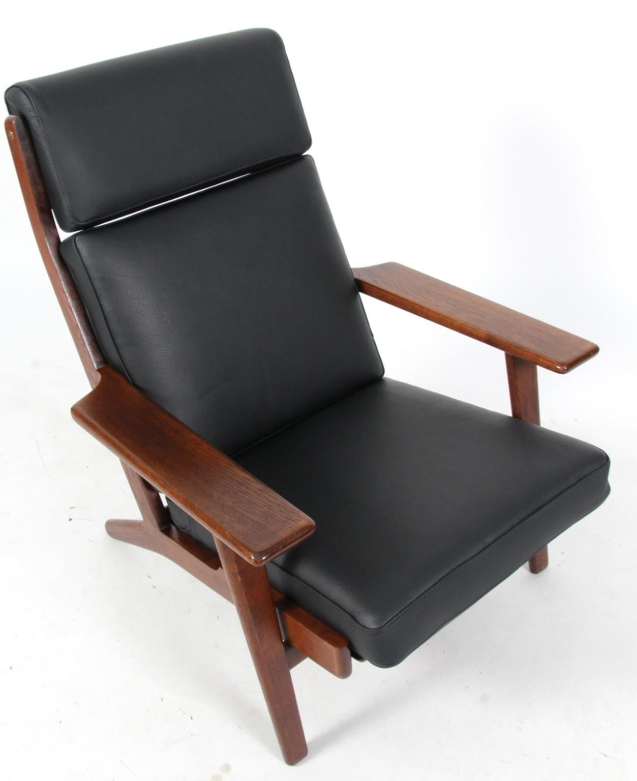 Hans J. Wegner lounge chair new upholstered with black leather, foam cushions.

Frame in smoked oak.

Model 290A, made by GETAMA.