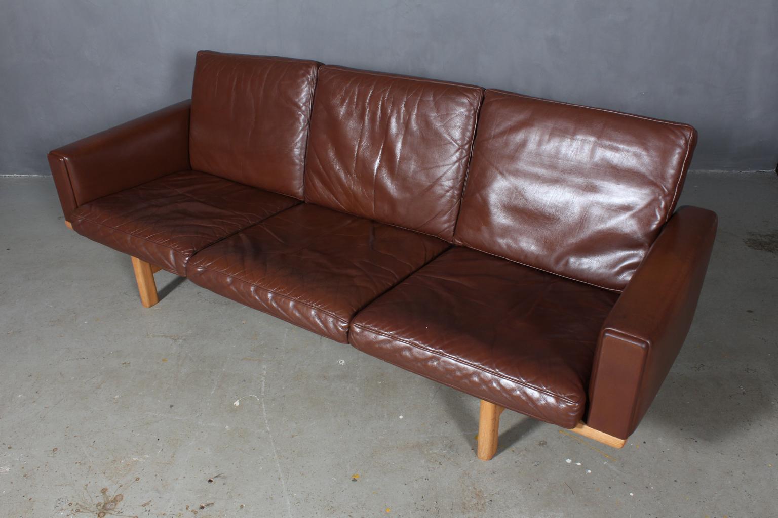 Hans J. Wegner three-seat sofa original upholstered in original brown patinated leather. 

Frame in solid oak.

Model 236/3, produced by GETAMA.