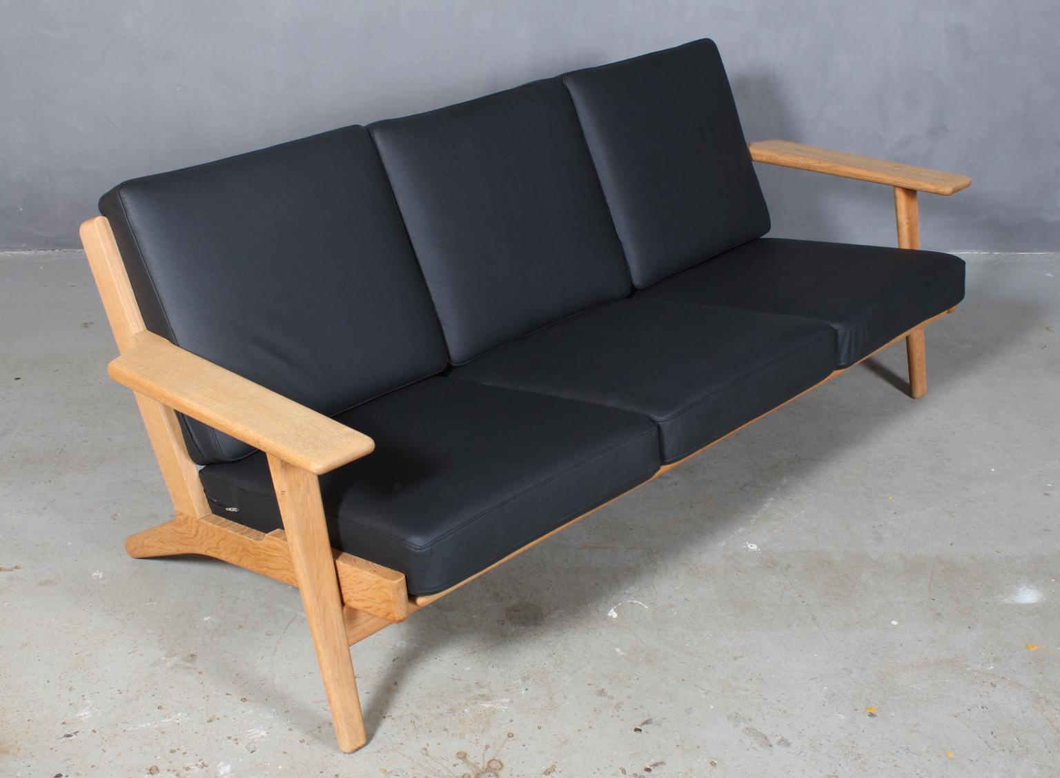 Hans J. Wegner three-seat sofa new upholstered with black leather, foam cushions.

Frame in soap treated oak.

Model 290/3, made by GETAMA.