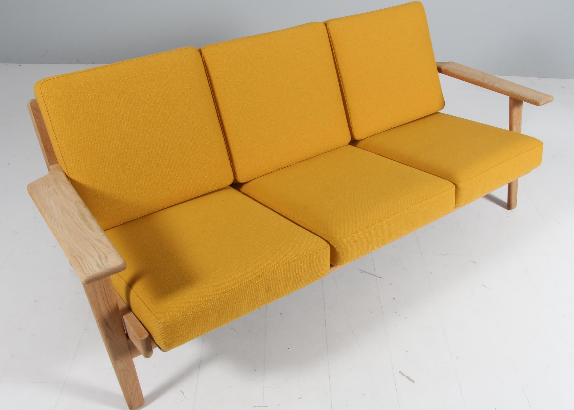 Hans J. Wegner three-seat sofa made of solid soap treated oak.

New upholstered with yellow fabric.

Model 290, made by GETAMA.

