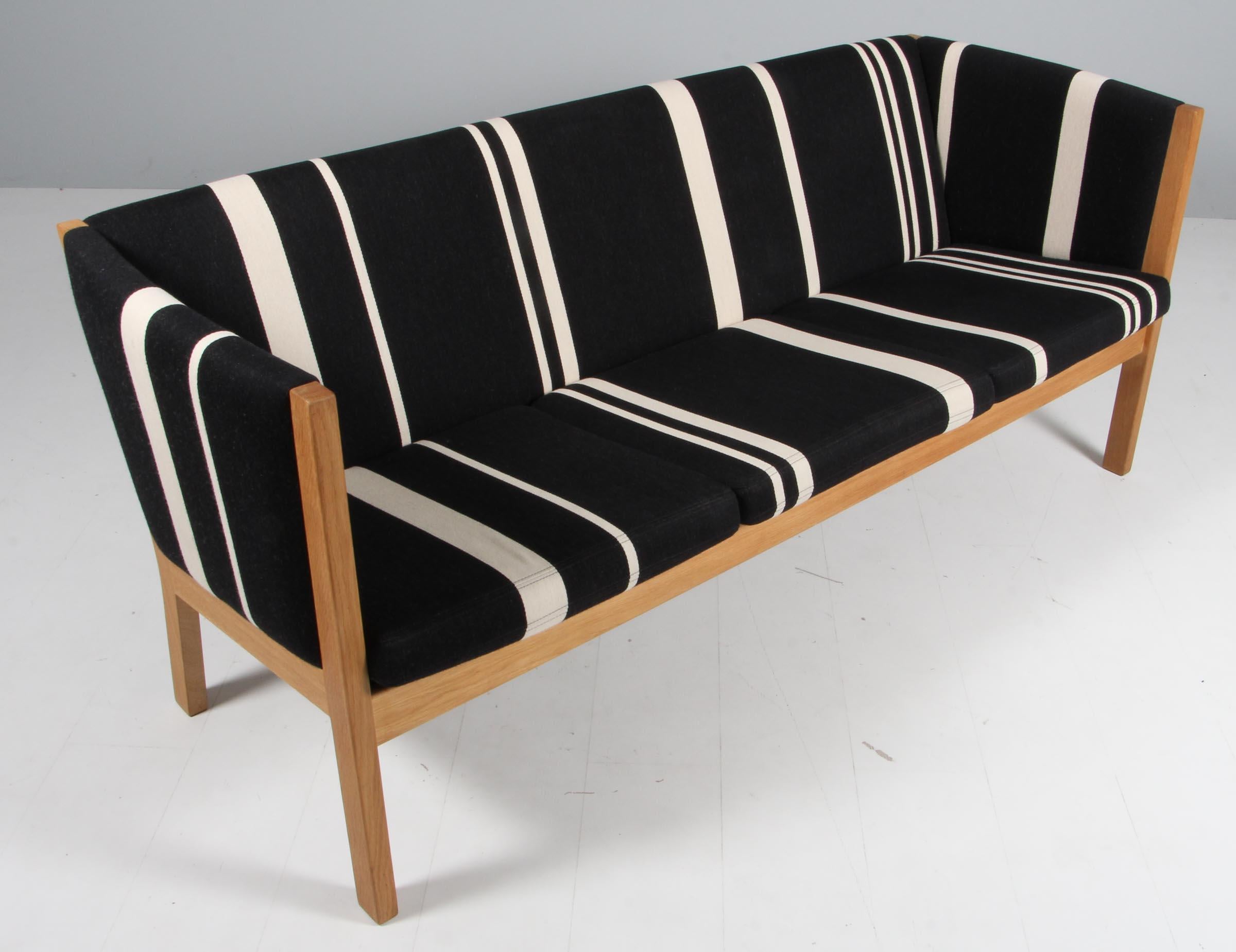 Hans J. Wegner three-seat sofa, original upholstered with striped Savak wool.

Frame in solid soap treated oak.

Model 285/3, produced by GETAMA.
