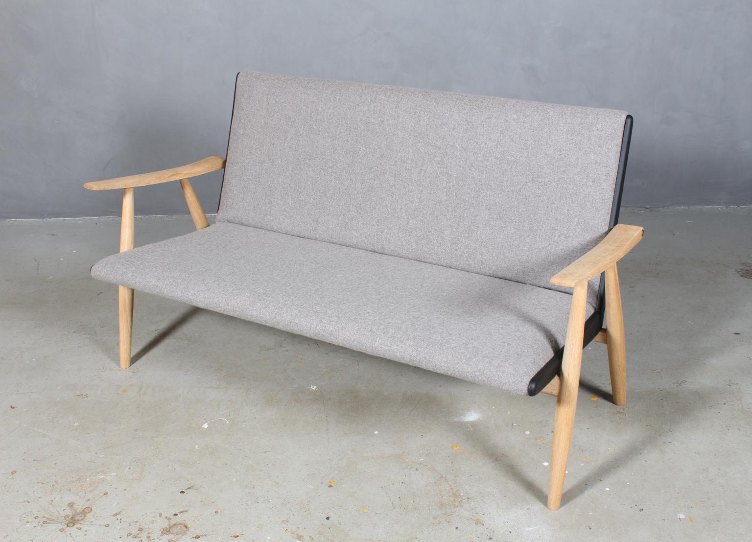 Hans J. Wegner two and a half seater sofa new upholstered with divina melange 100 % New Zealand wool and leather.

Solid soap treated oak frame. Brass screws.

Model Ge-260/2½, made by GETAMA, 1960's..