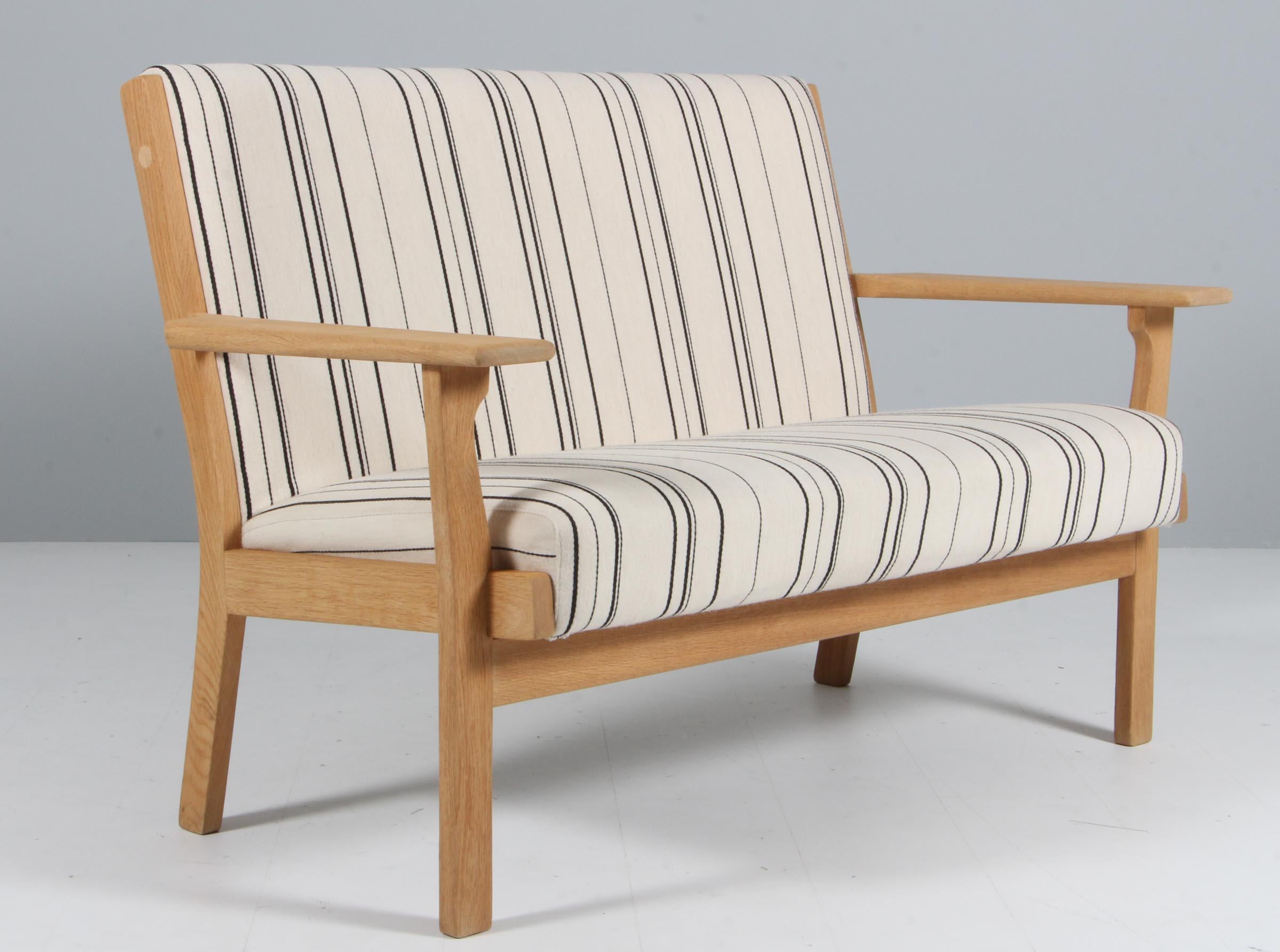 Hans J. Wegner two seat sofa with frame of soap treated oak.

Upholstered with stribed Savak fabric from Gabriel.

Made by getama.