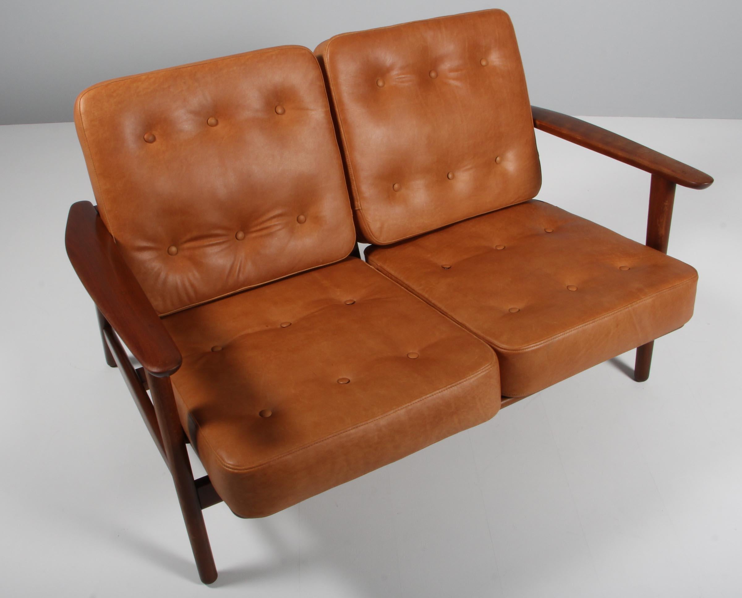 Hans J. Wegner two seat sofa with loose cushions new upholstered with cognac aniline leather with buttons.

Stained beech.

Model 233, made by GETAMA.