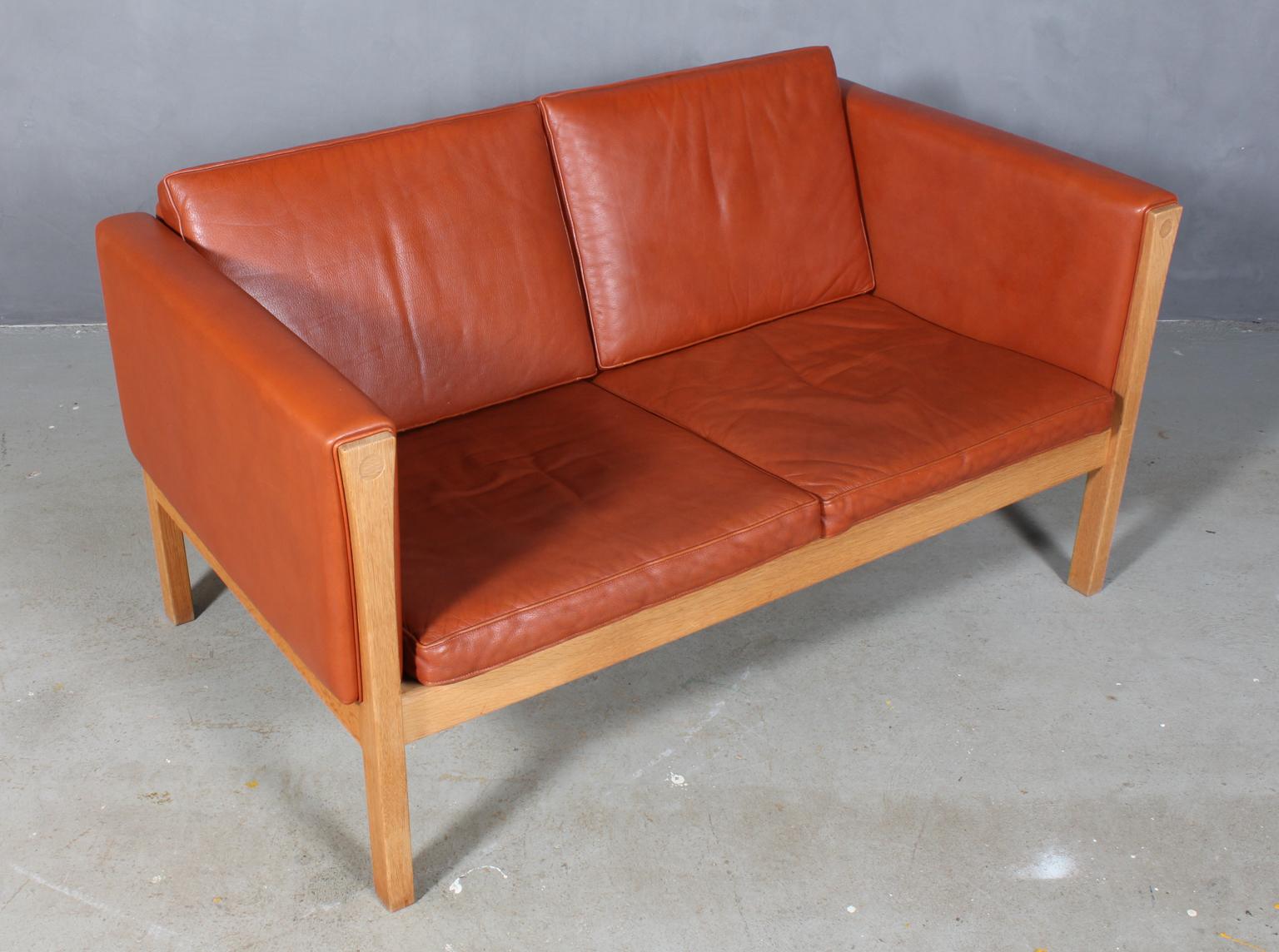 Hans J. Wegner two-seat sofa, original upholstered with cognac leather.

Frame of solid oak.

Model AP 62/2, made by AP.