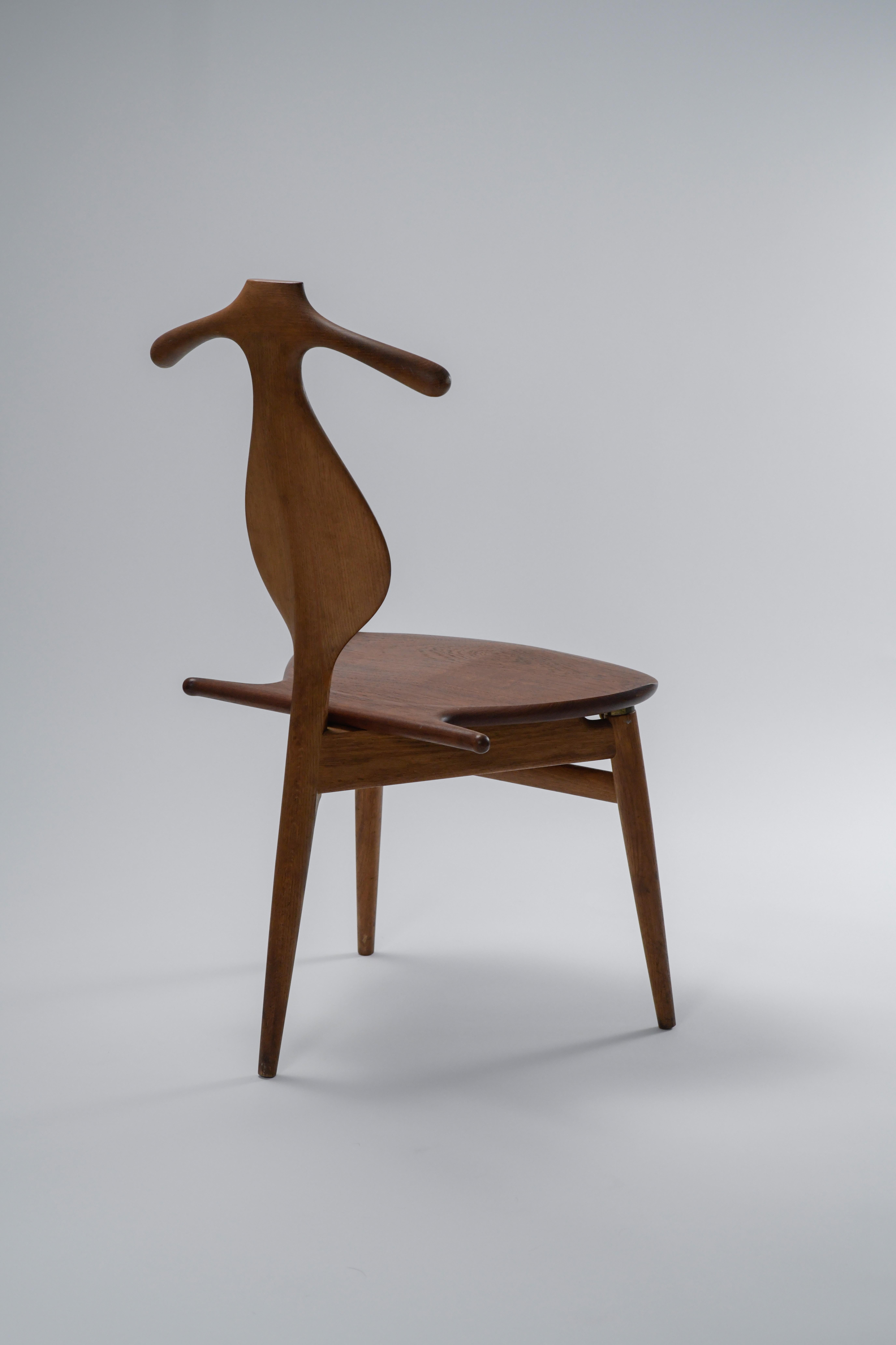 Modell JH-540 Valet Stuhl von Hans J. Wegner für Johannes Hansen. 

Dieses prächtige Stück Design aus der Mitte des Jahrhunderts ist ebenso funktionell wie schön. Der Sitz lässt sich hochklappen, um eine Ablage für Hosen zu schaffen, und gibt ein