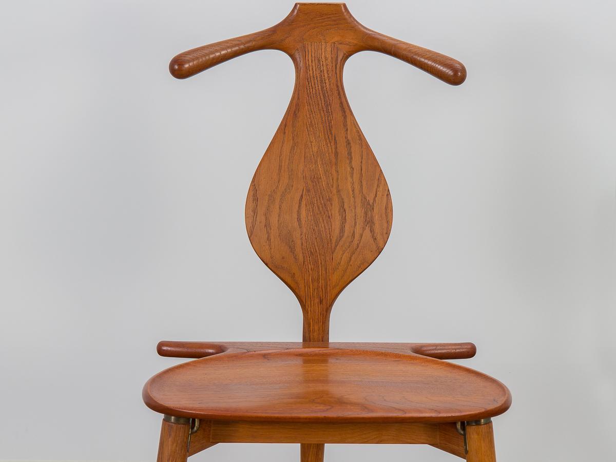 Exquise chaise de valet modèle JH-540, conçue par Hans J. Wegner pour l'ébéniste Johannes Hansen. Conçue à l'origine pour un roi, aucun détail n'est négligé dans son exécution. La forme sculpturale est taillée dans du bois de chêne massif, mettant