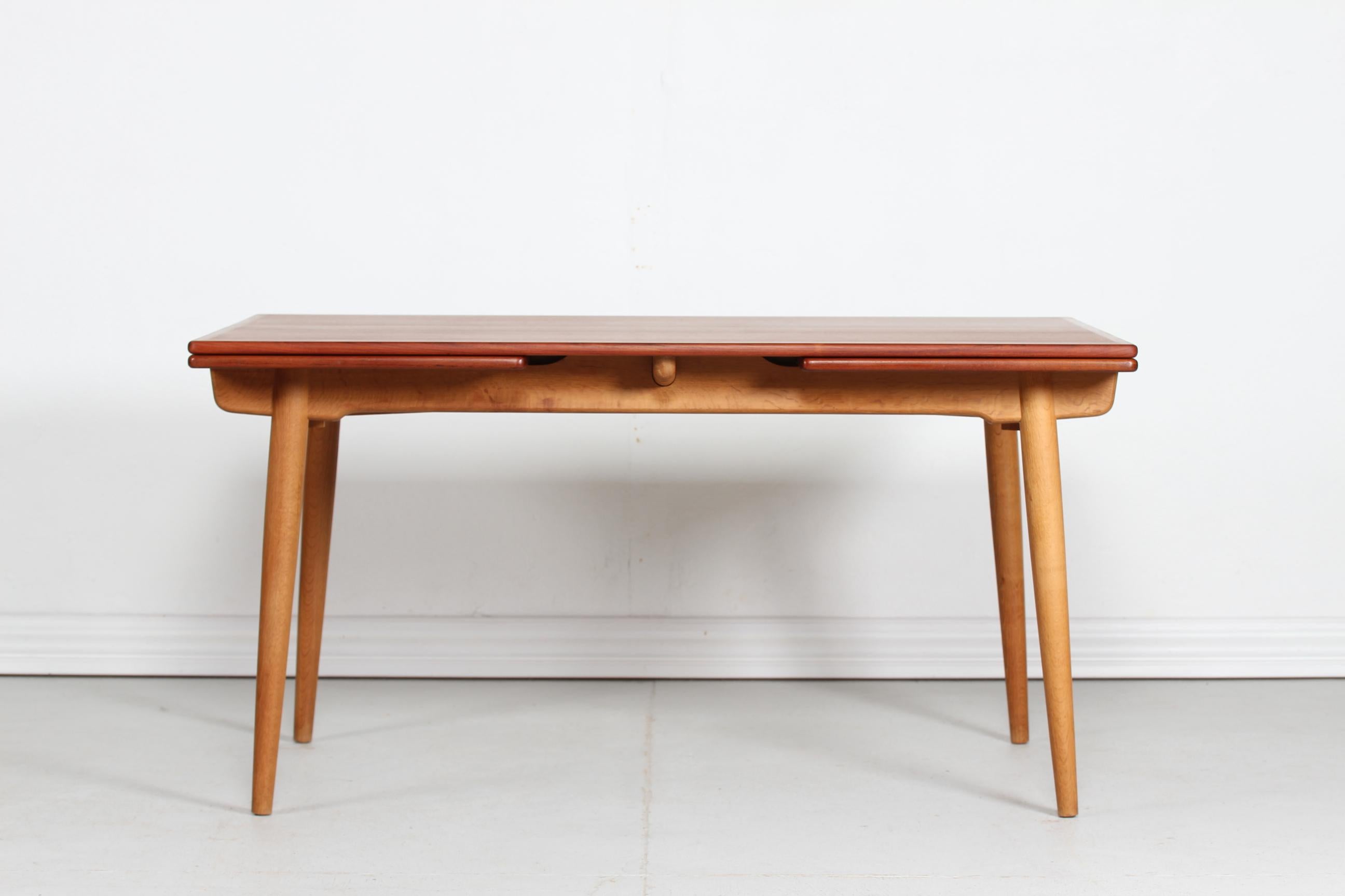 Dining table model AT 312 by the Danish architect Hans J. Wegner and manufactured by Andreas Tuck in the 1950s.

The dining table has a frame of solid oak and a top of teak veneer. Two pull-out-leaves make extension possible. The two leaves hide