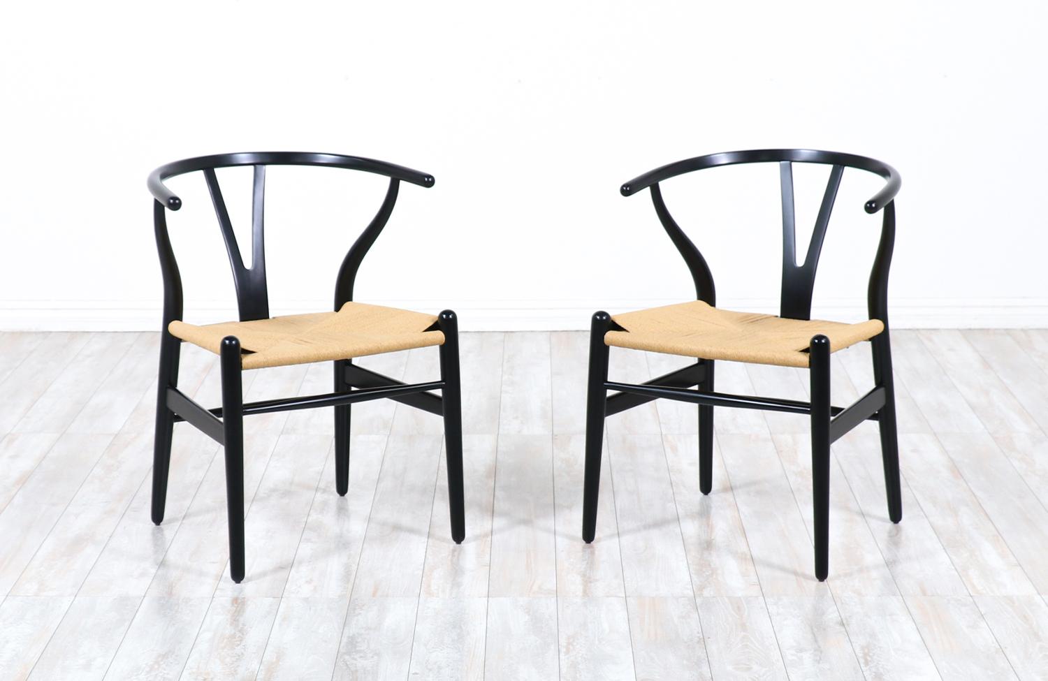 Pair of CH-24 arm chairs designed by Hans J. Wegner for Carl Hansen & Søn in Denmark in 1950. Often referred to as the ‘Wishbone’ chair or the ‘Y’ chair, this iconic design with Chinese influences, features an ebonized wood frame and the new rush