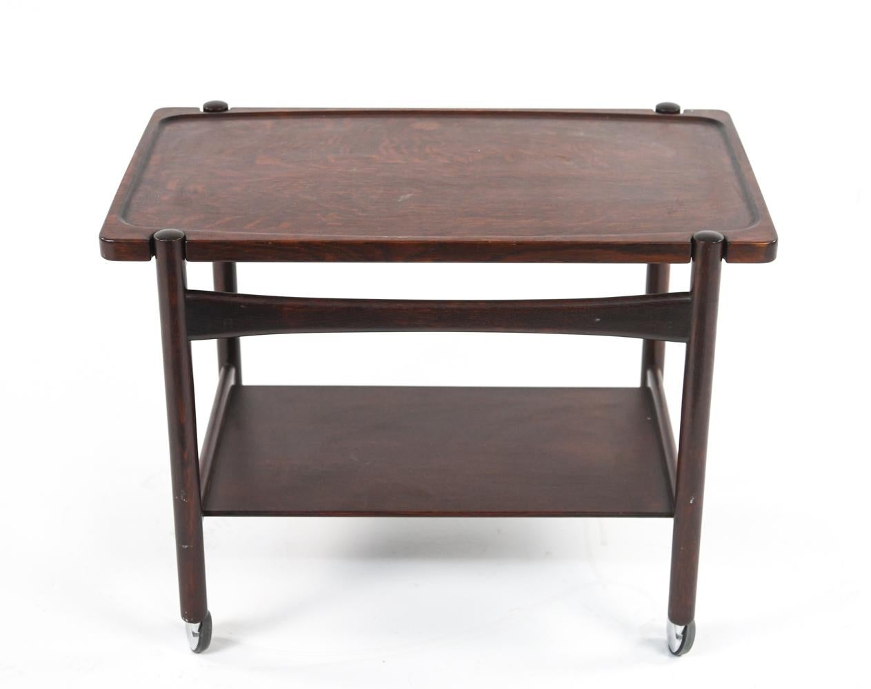 Impressive Danish mid-century bar cart or tea trolley with removable tray top on rolling base. Designed by Hans J. Wegner for Andreas Tuck. In richly stained oak with warm red tone reminiscent of rosewood. Stamped underneath with Andreas Tuck