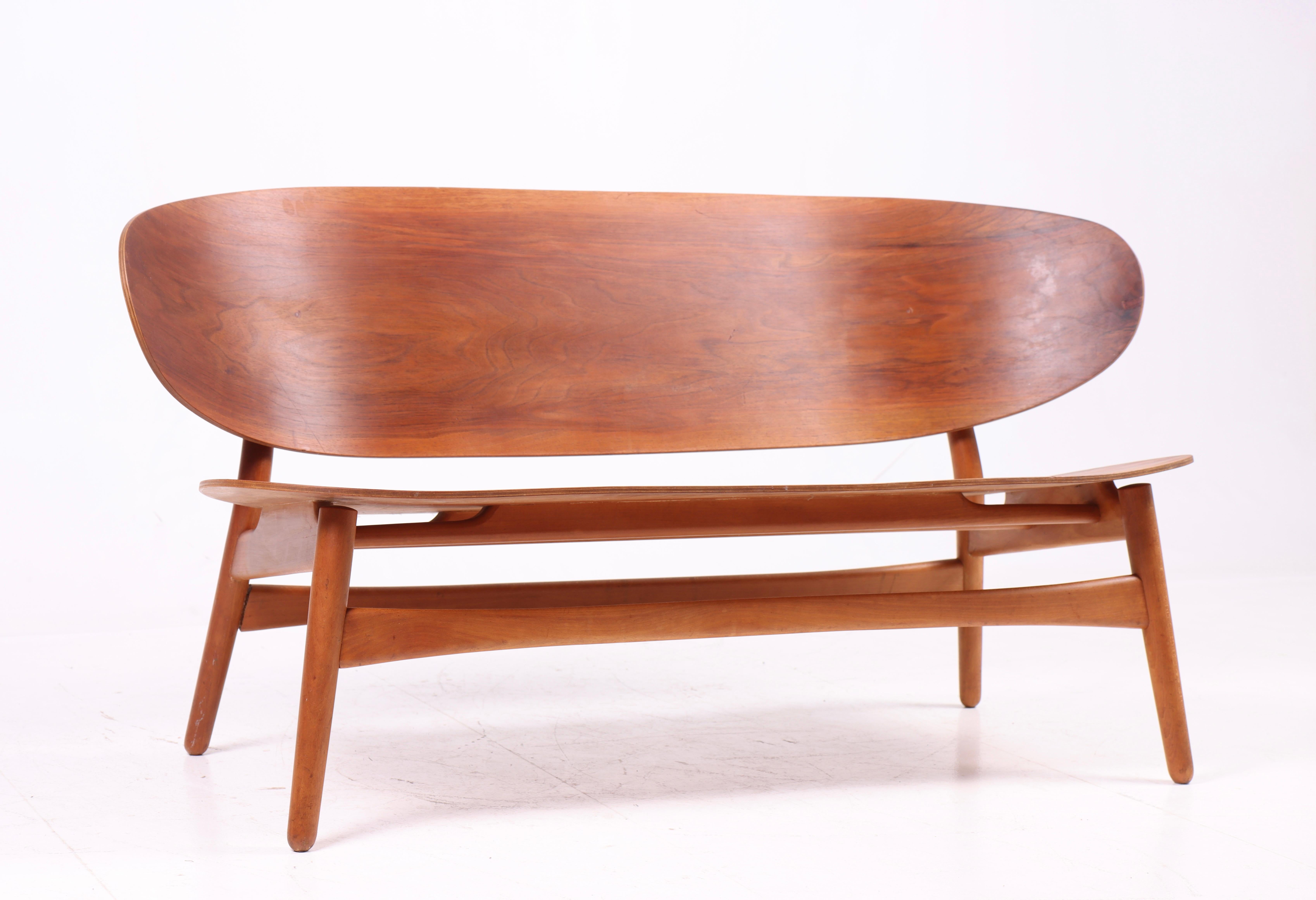 This shell sofa, model FH 1936, was designed by Hans Jørgen Wegner and produced by Fritz Hansen in the 1950s. Made from beech wood, the sofa features an organic design characteristic of Wegner's work. The sculptural shell shape gives the sofa a