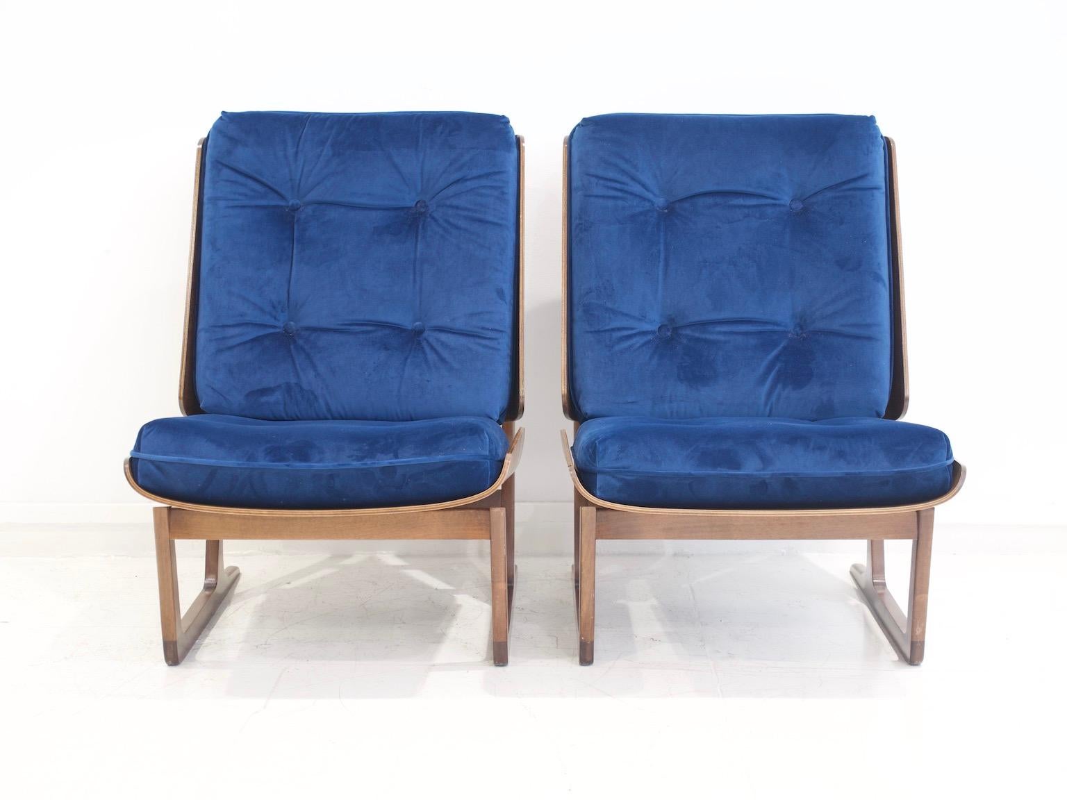 Pair of lounge chairs designed by Hans Juergens for Deco House in the early 1960s. Molded walnut plywood shell supported by a solid walnut sled-form frame. Cushions later upholstered in royal blue velvet.

The design of this lounge chair was for