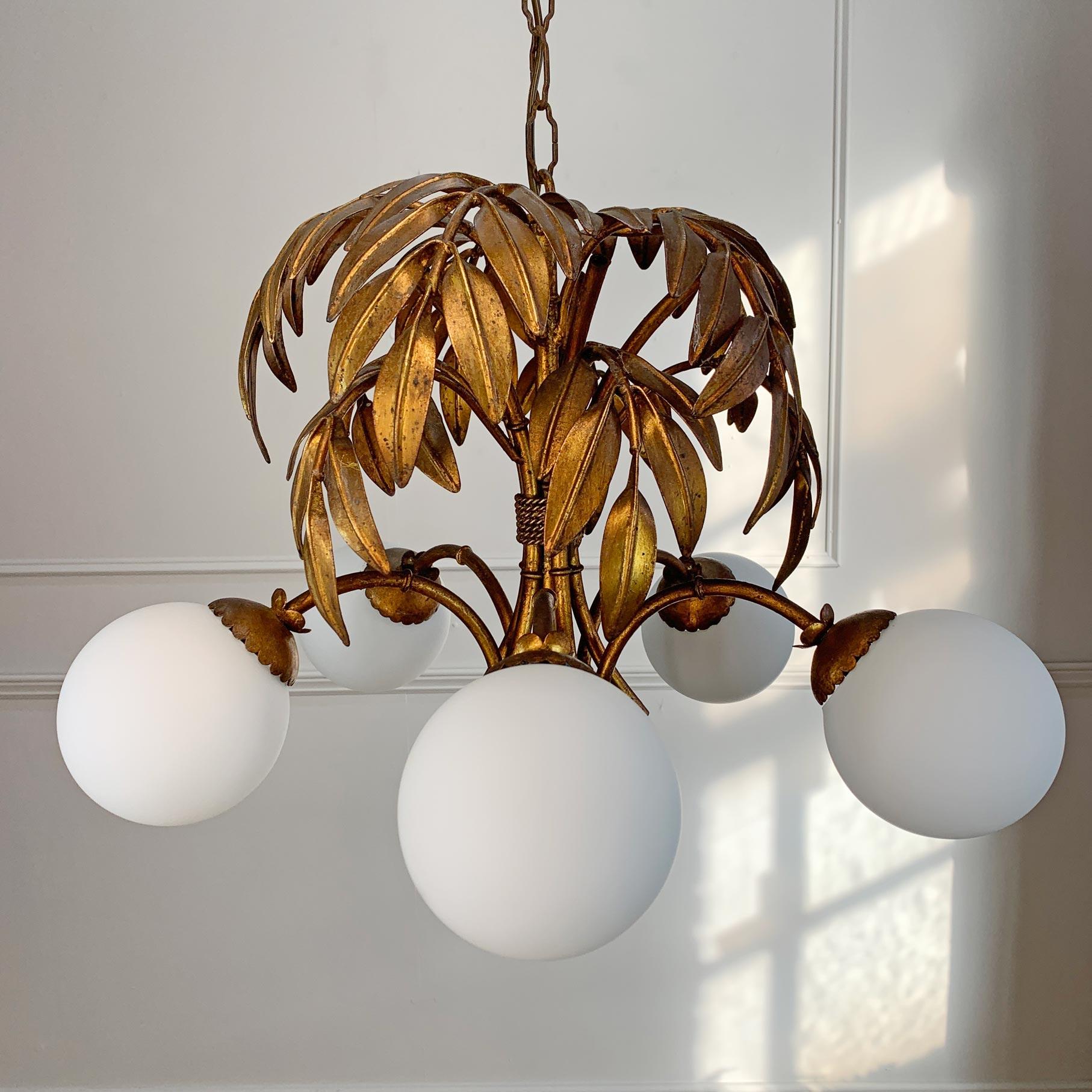 Stunning gilt bronze Hans Kogl chandelier dating to the 1970’s, the gilded bamboo leaf canopy and faux bamboo arms, each housing a single e14 (small screw in) lamp holder, these sit beneath matt glass globe shades.



Wear and Patina to the leaves