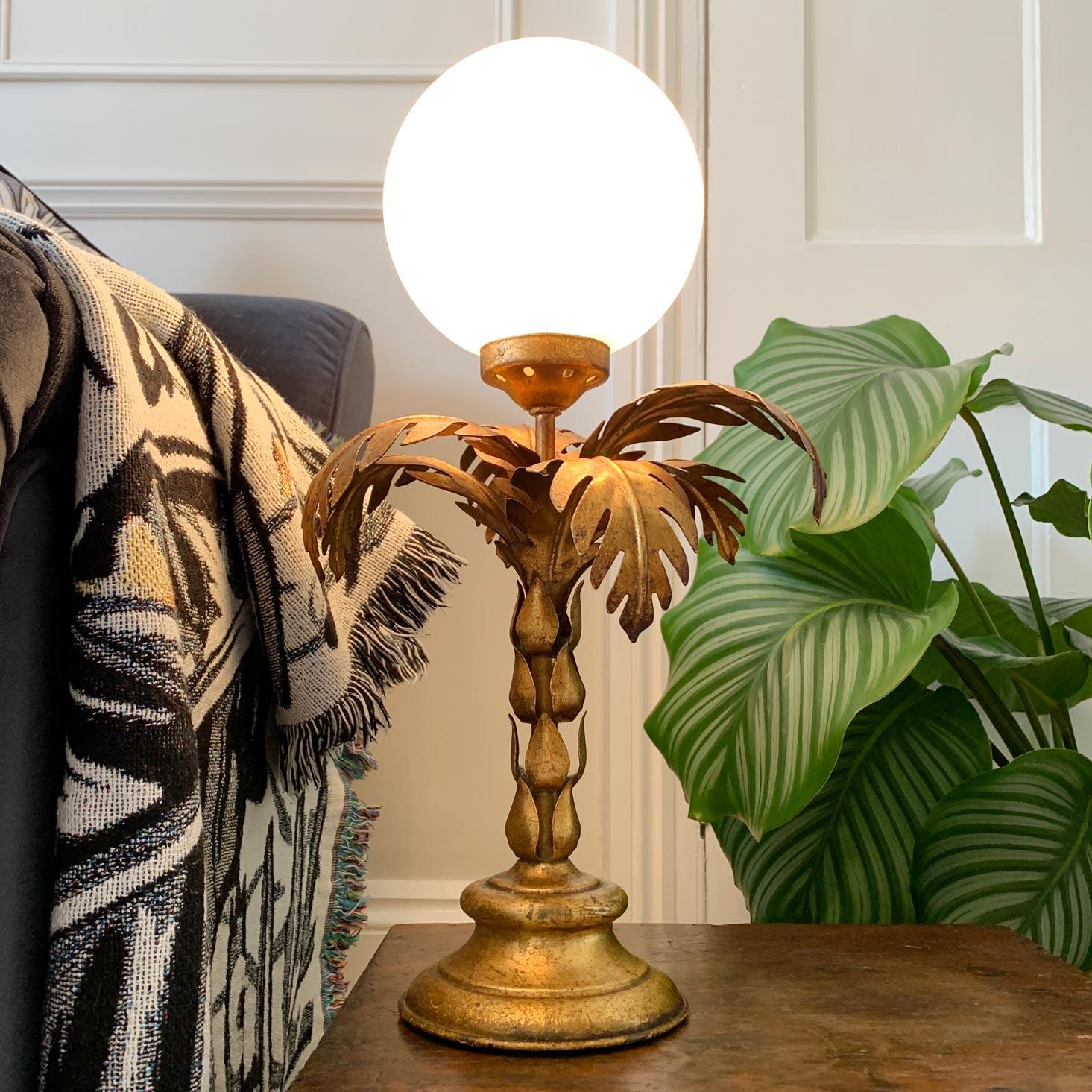 Lampe palmier Hans Kogl en métal doré avec abat-jour globe opalescent, vers 1970 

Hauteur 46 cm, largeur de la base 13 cm, largeur de la feuille au sommet 26 cm, globe d'environ 16 cm de largeur.

L'éclairage est câblé, en parfait état de