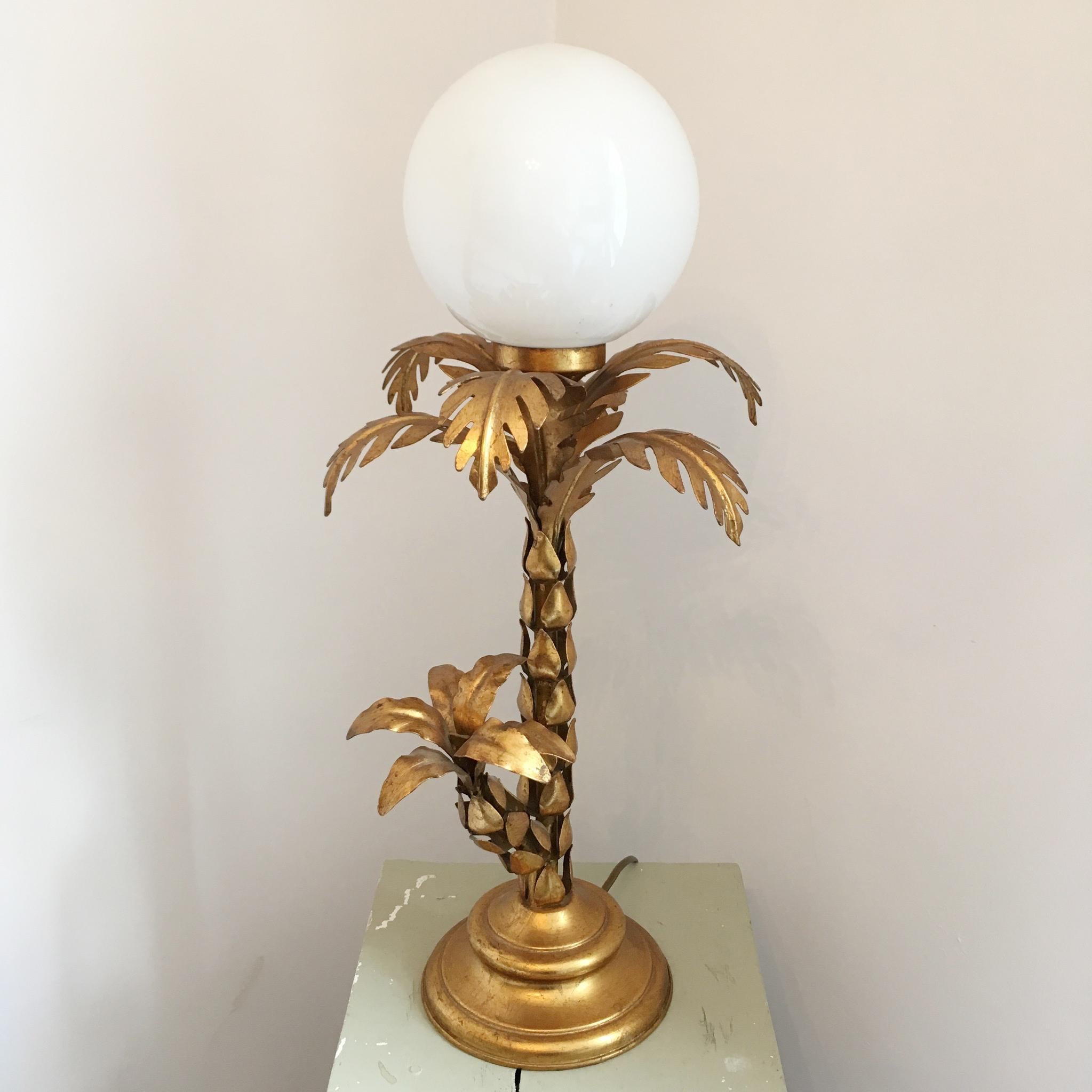 Hans Kogl gilt palm tree lamp, Belgium, circa 1970s, gilt metal palm tree lamp with opalescent globe shade.
Measures: Height 58cm, base width 17cm, leaf width at top 26cm.


 