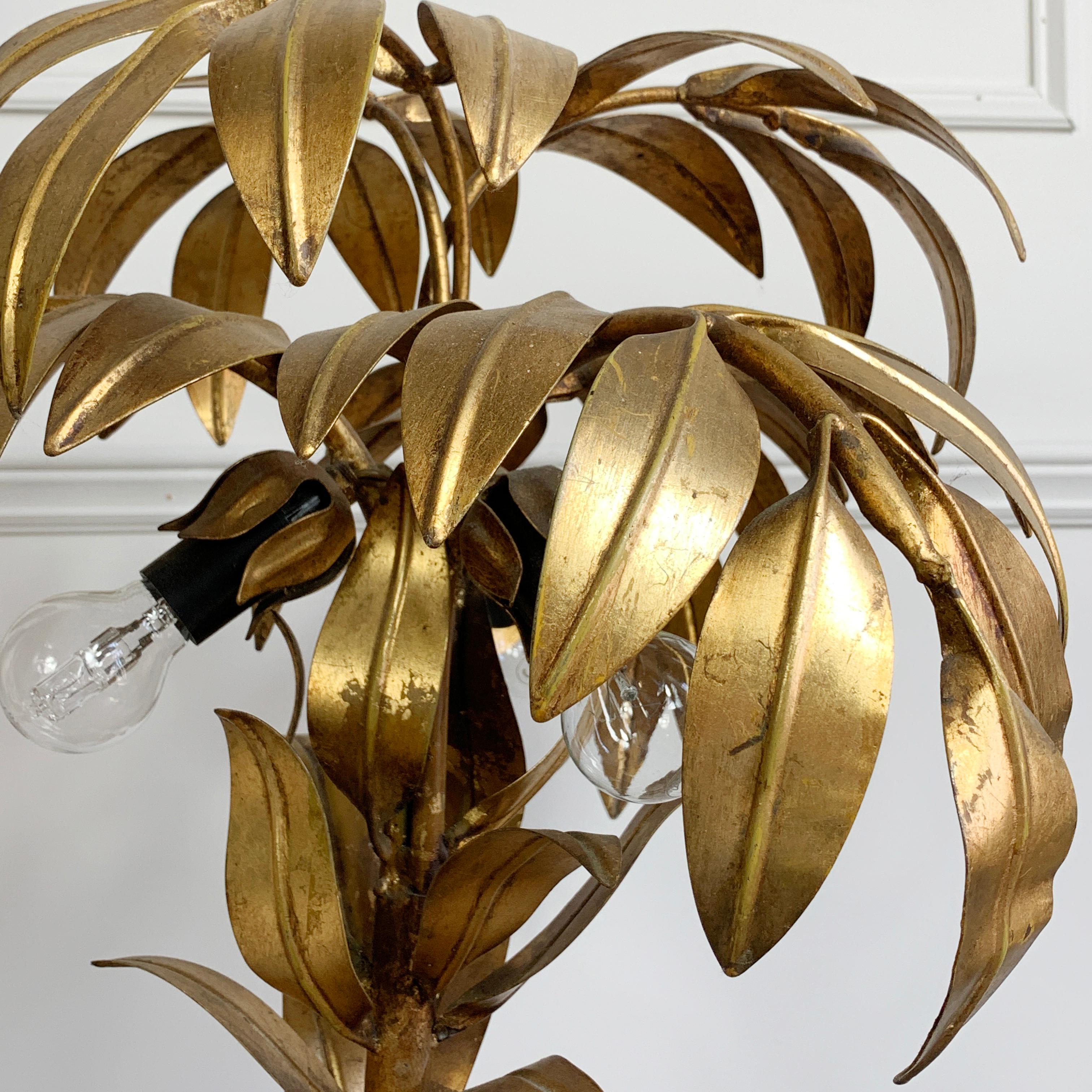 Stunning gilt metal palm tree lamp by Hans Kogl,  1970's Germany. Fronds of leaves arranged to form a beautiful gilt statement palm tree. This iconic palm tree lamp has 3 bulb holders hidden under the leaf canopy, taking e14 bulbs

Original gold